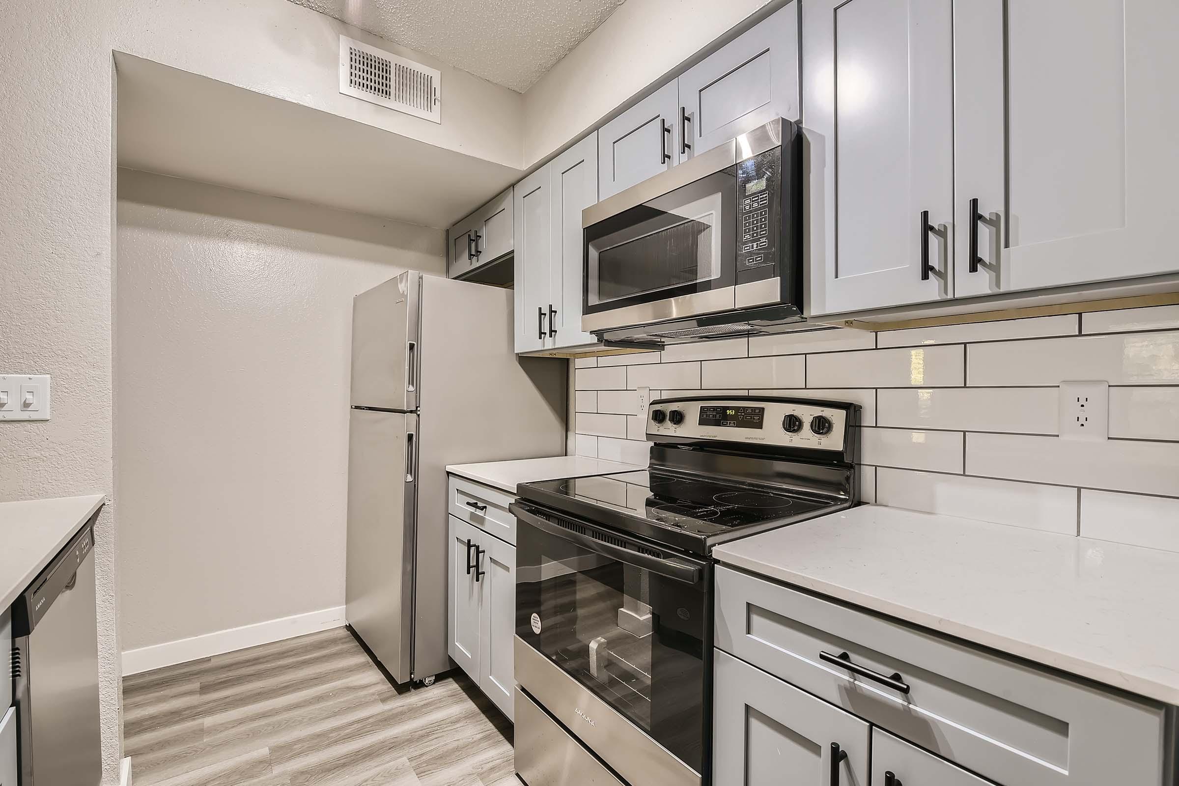 Stainless steel appliances inside of a kitchen in Rise Bedford Lakes apartments in Bedford, TX