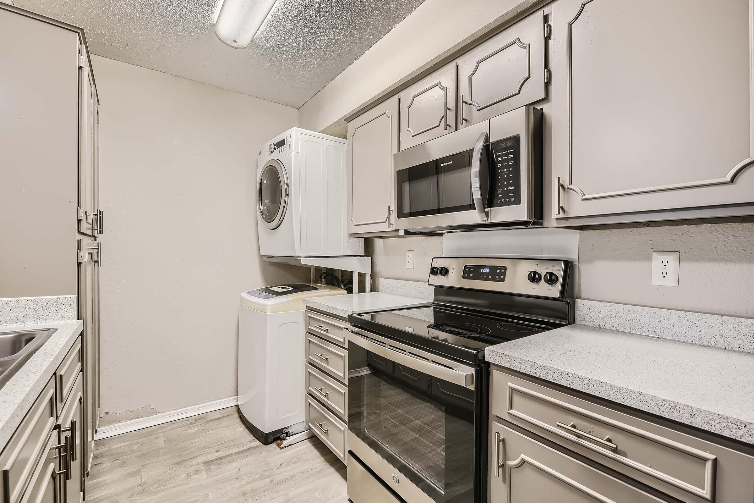 Bedfored, TX apartment kitchen with stove, microwave, and washer/dryer