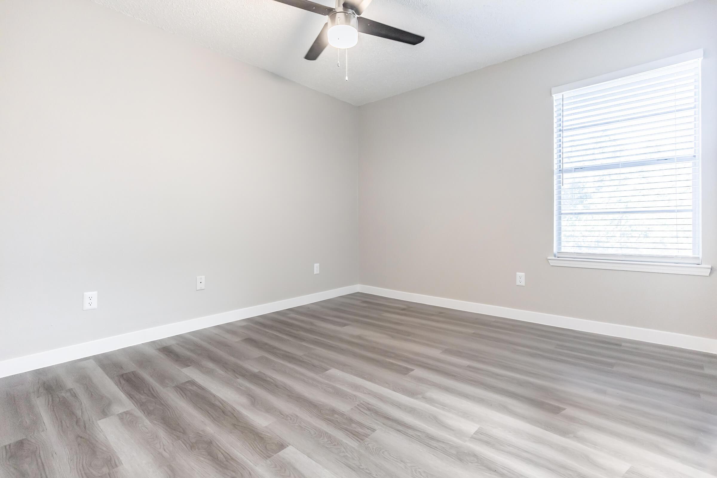 Empty Bedford, TX apartment bedroom with hardwood floors and a ceiling fan