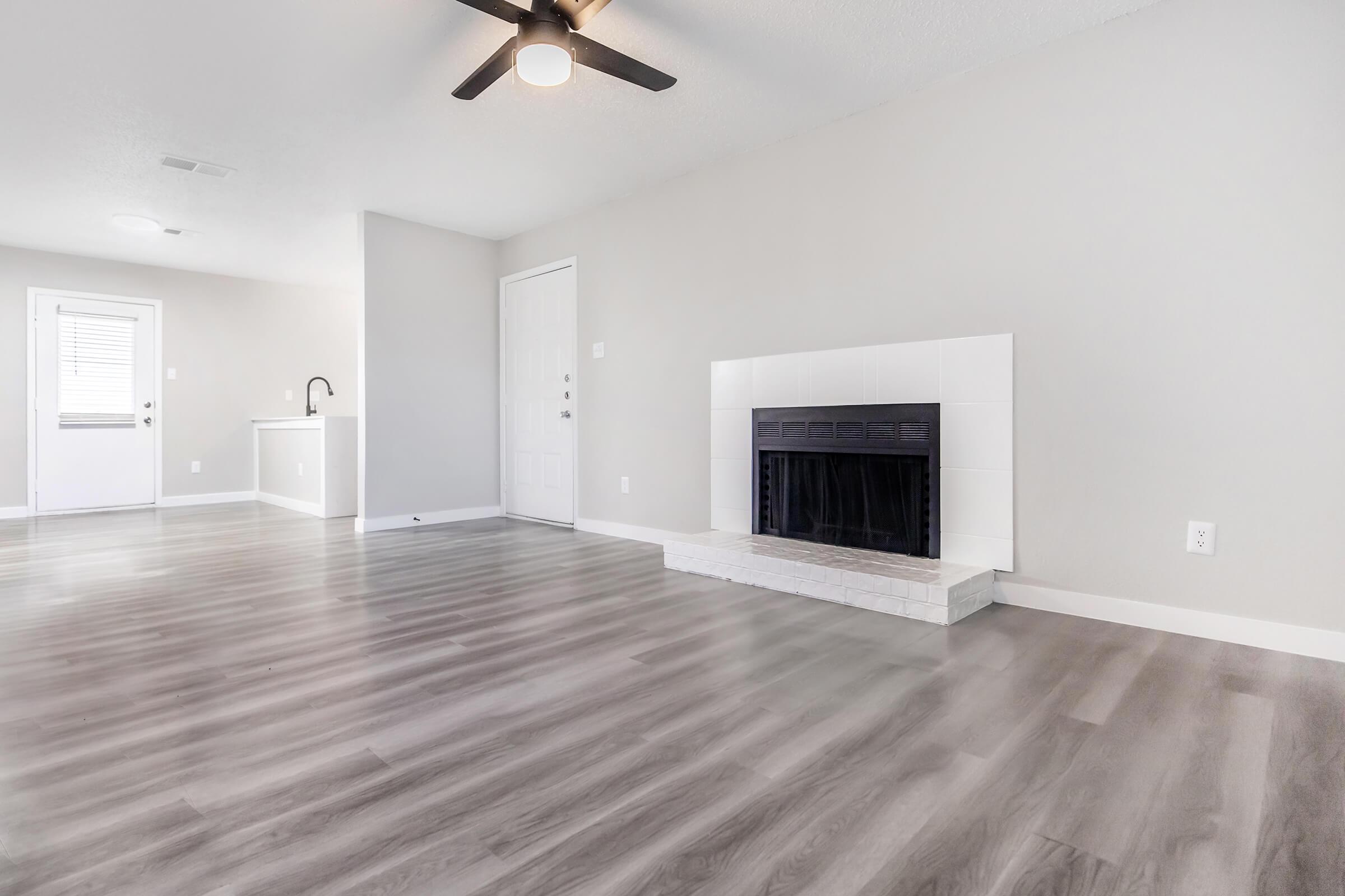 Empty Bedford, TX apartment living room with fireplace and ceiling fan