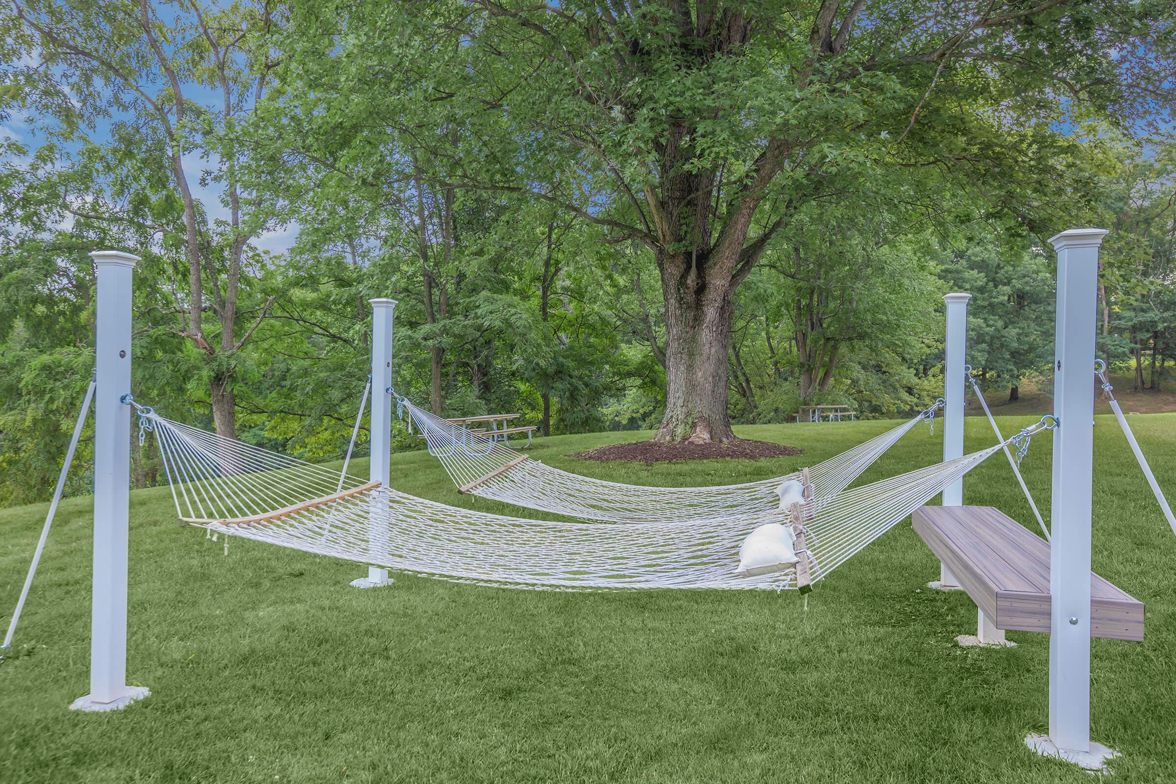 a couple of lawn chairs sitting on top of a grass covered field