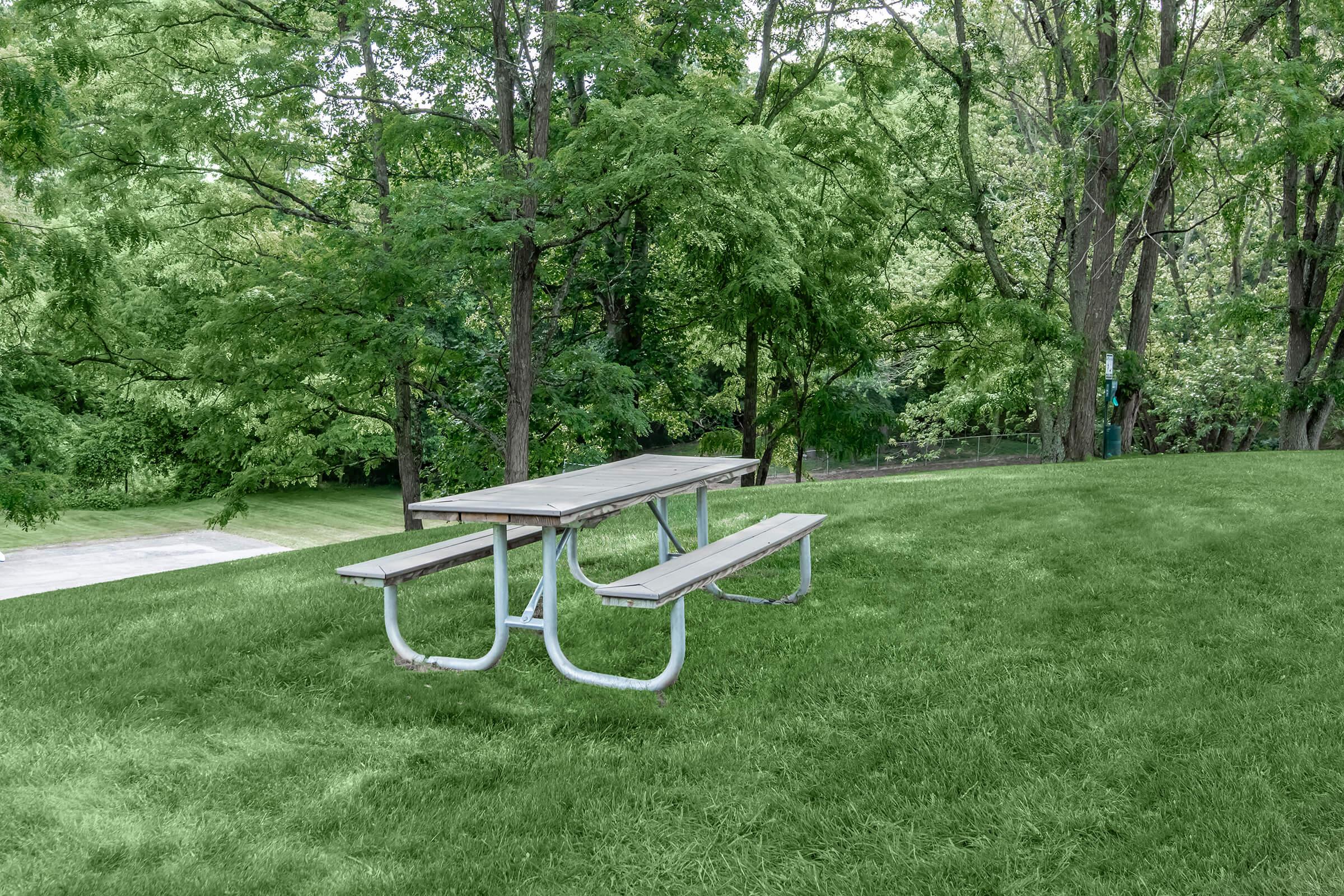 a couple of lawn chairs sitting on top of a bench in a park