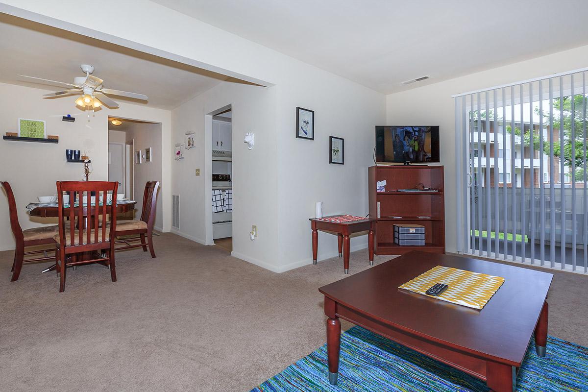 a living room filled with furniture and a dining table