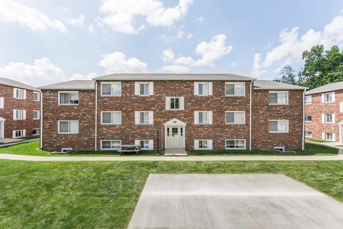 a large brick building with grass in front of a house