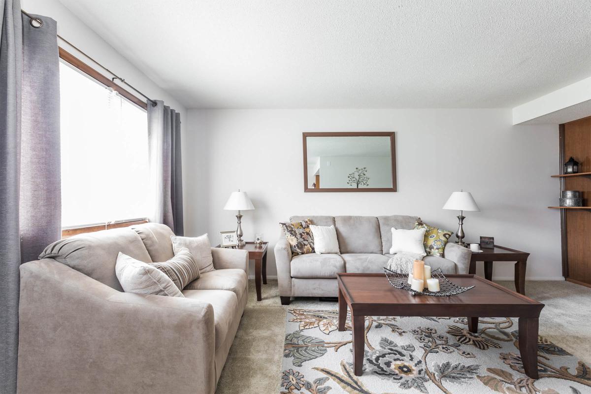 a living room filled with furniture and a large window