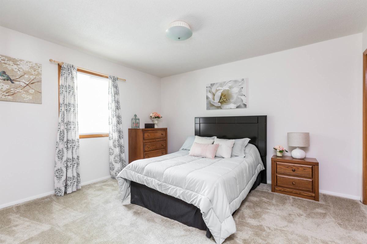 a bedroom with a bed and desk in a room