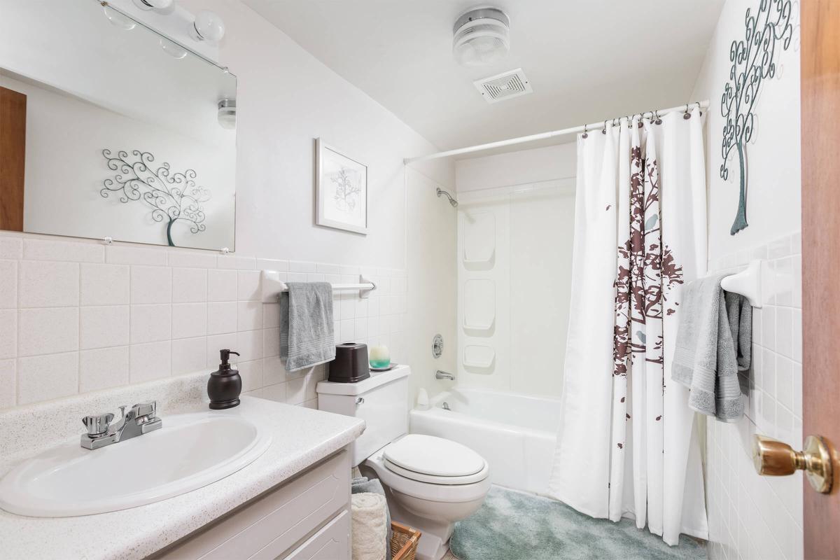 a white sink sitting under a mirror