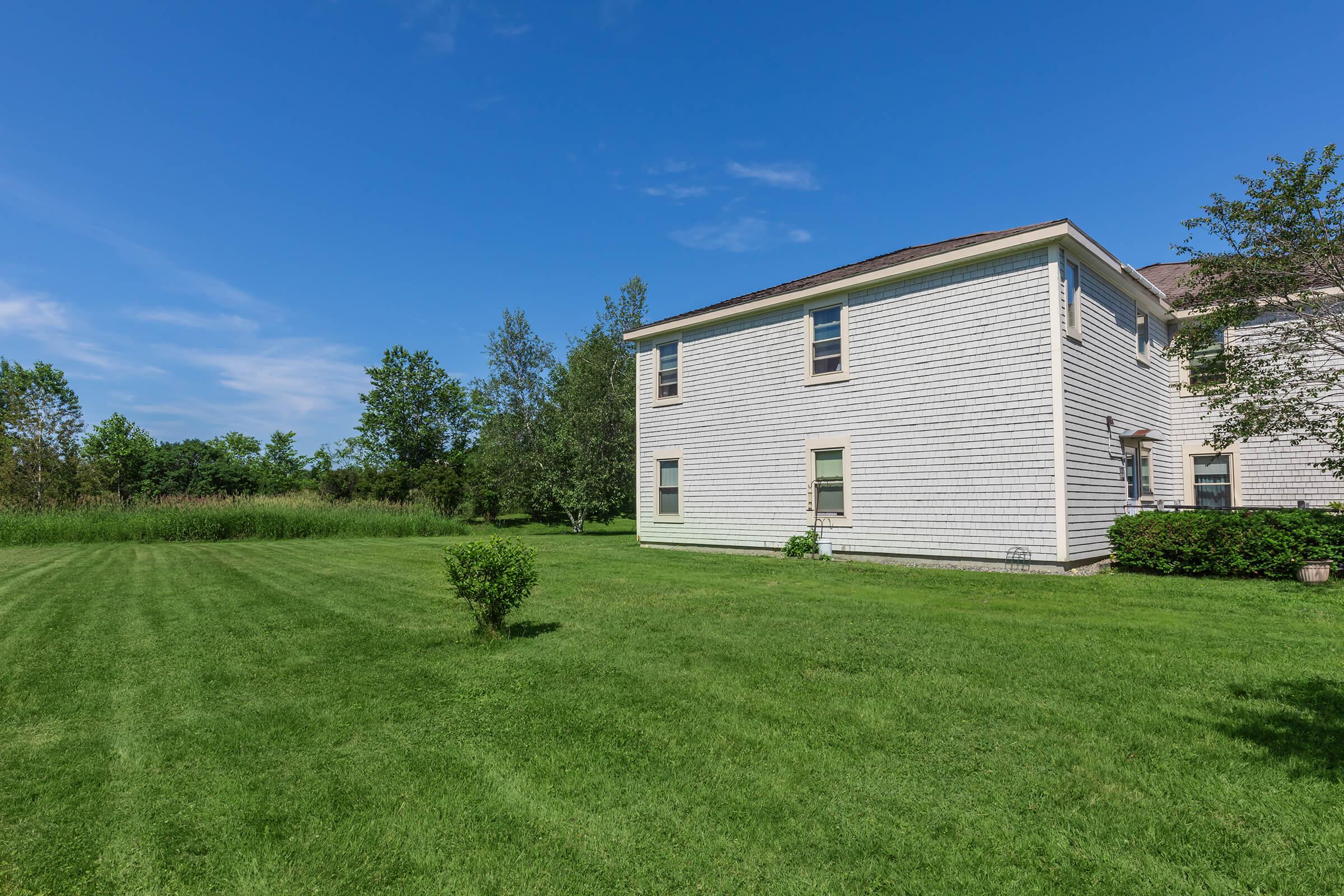 a large green field in front of a house