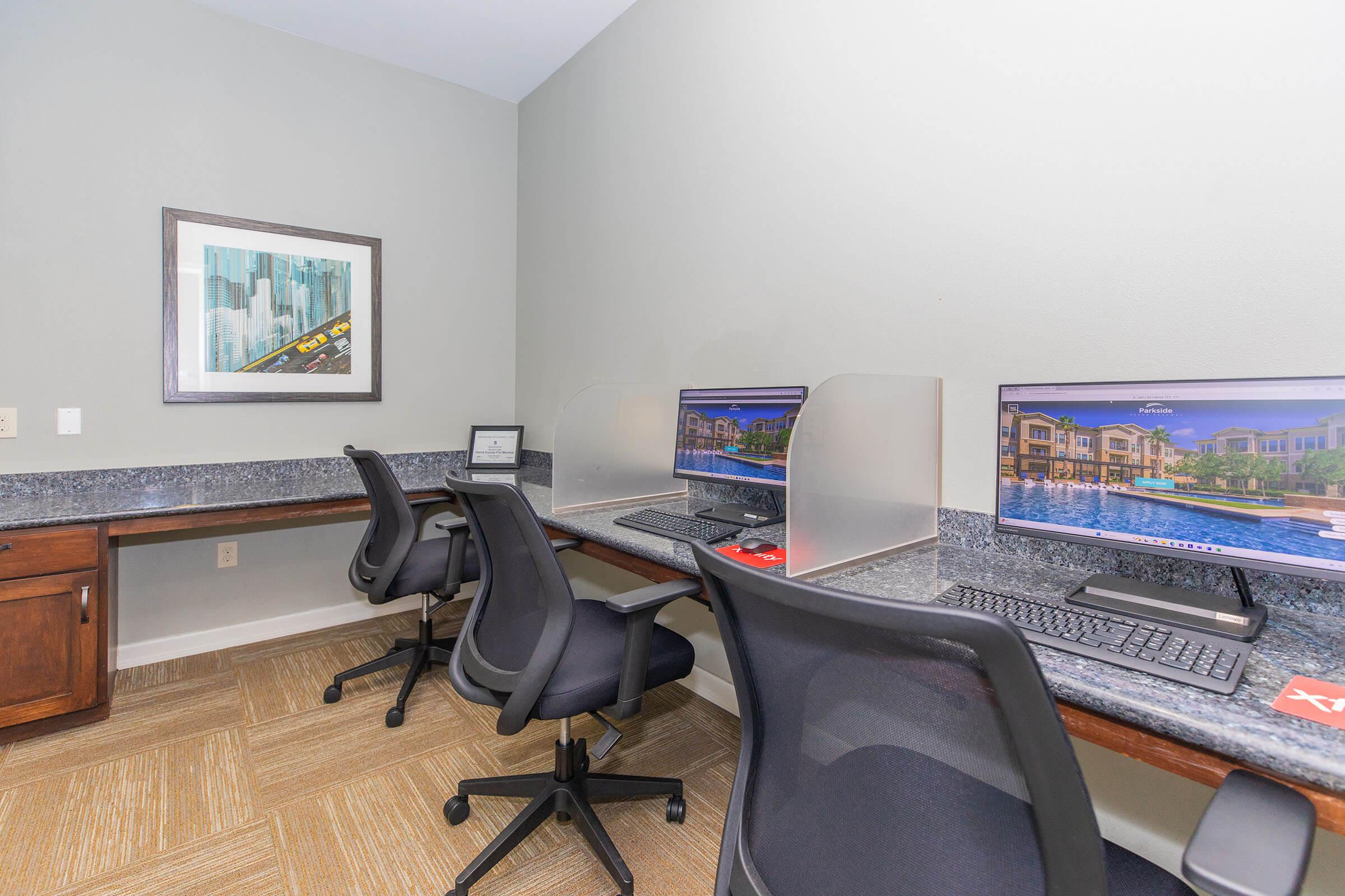 a desk with a computer and a chair in a room