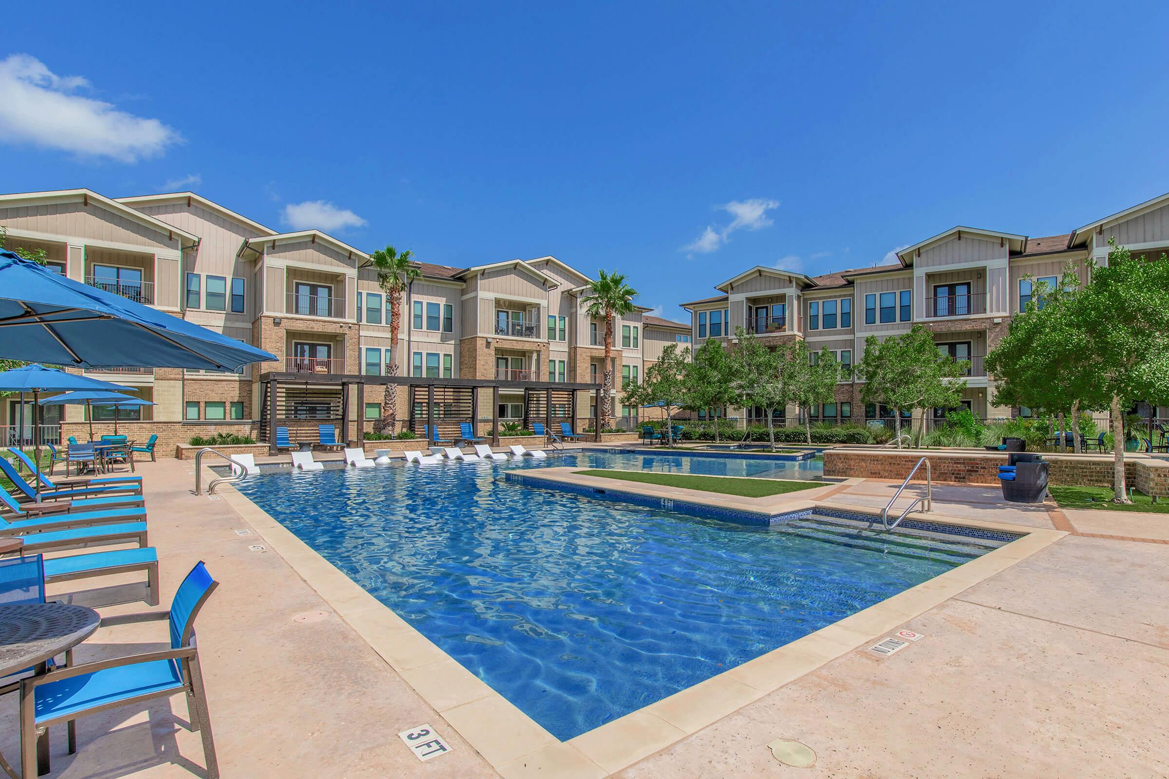 a group of lawn chairs sitting next to a pool of water