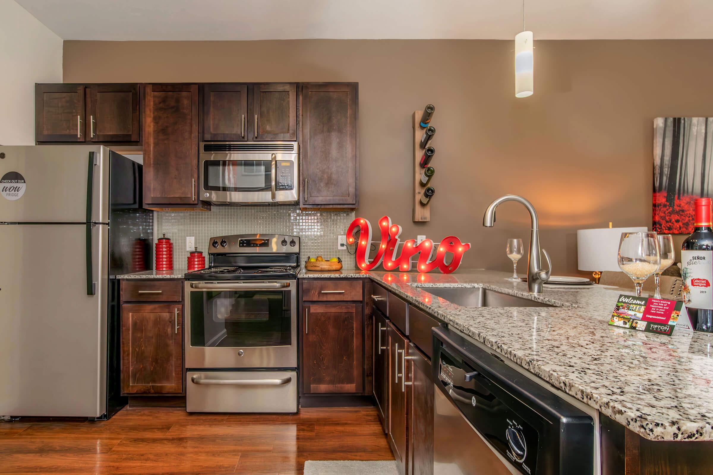 a modern kitchen with stainless steel appliances and wooden cabinets