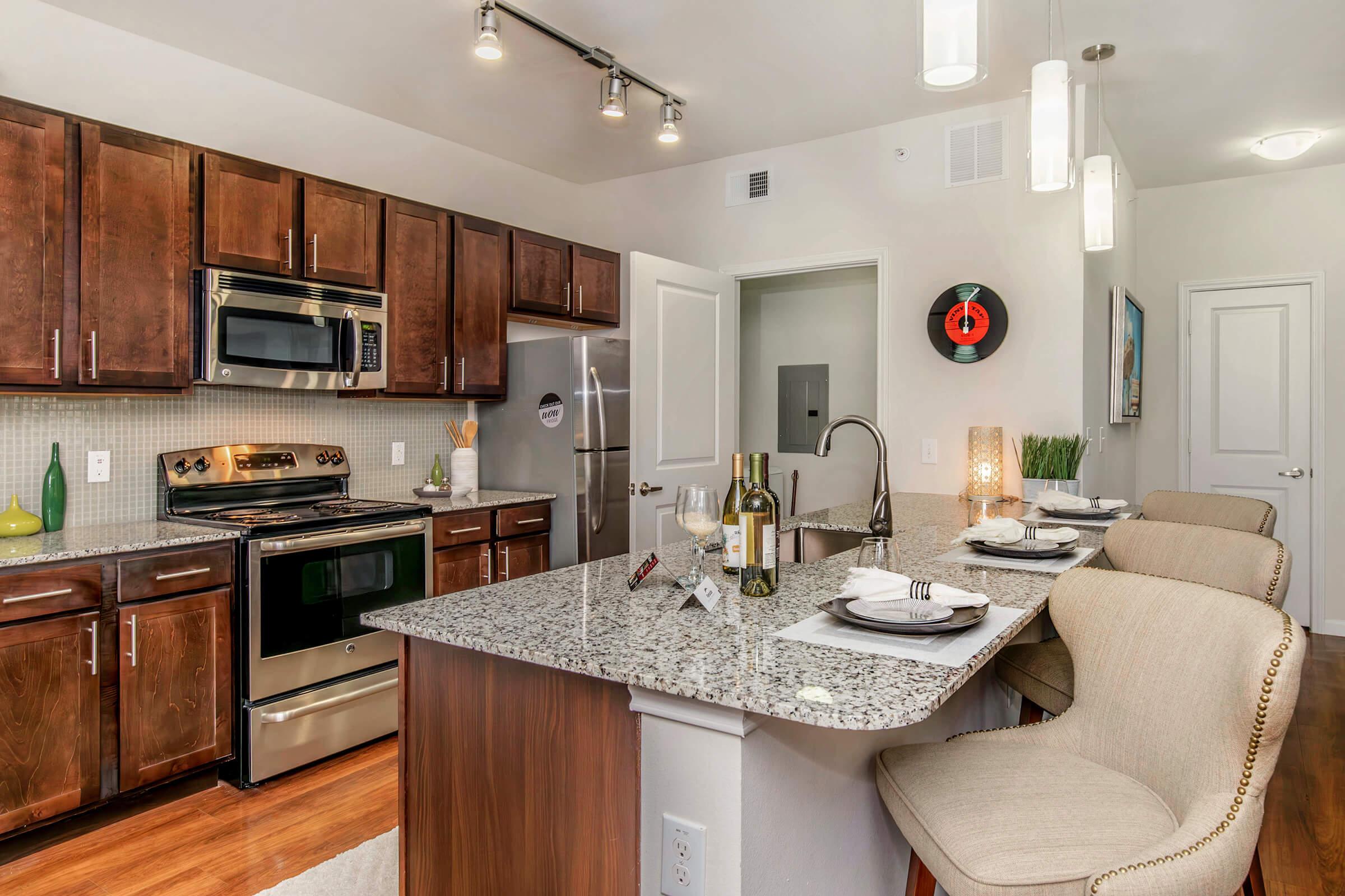 a modern kitchen with stainless steel appliances and wooden cabinets