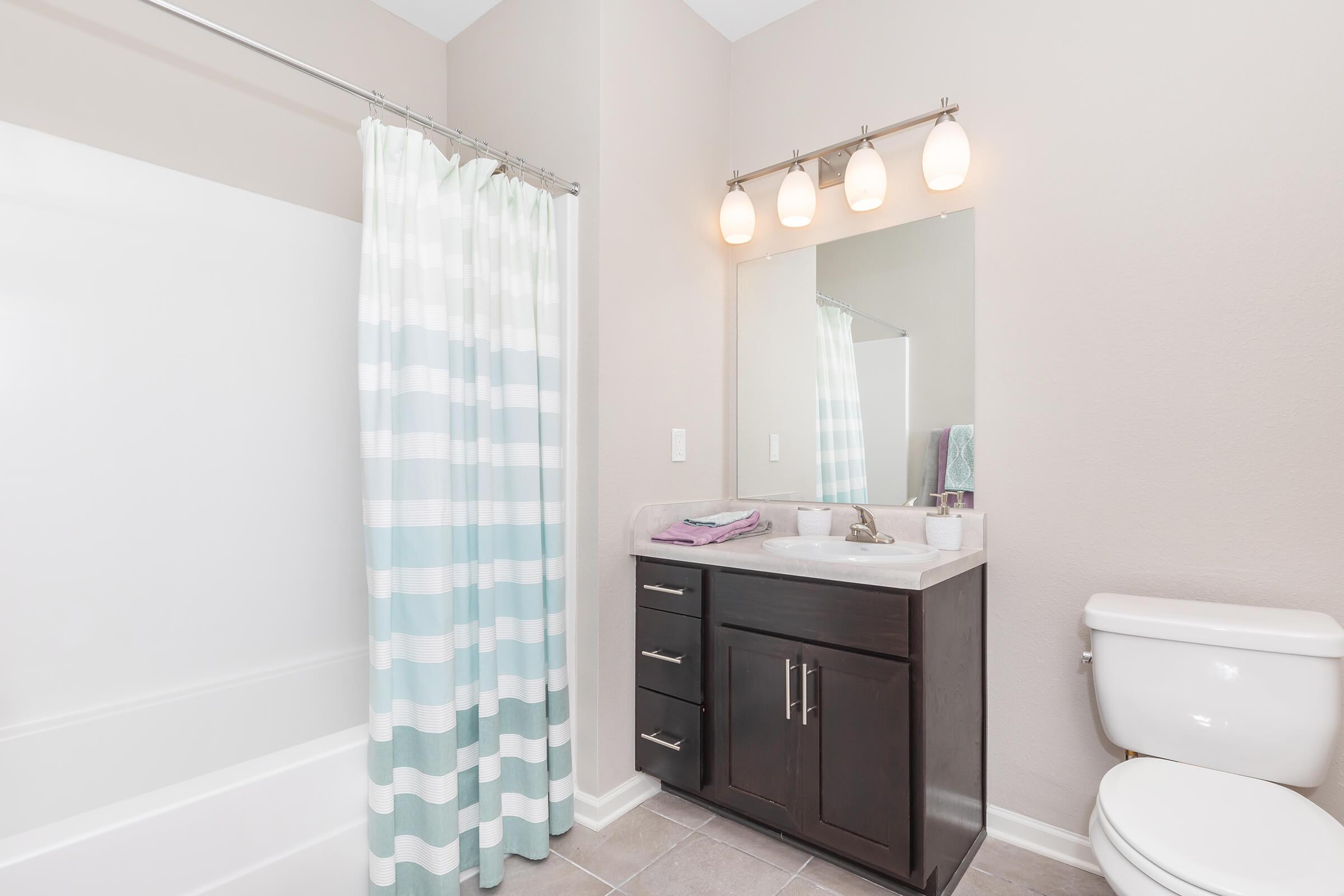 a white sink sitting next to a shower