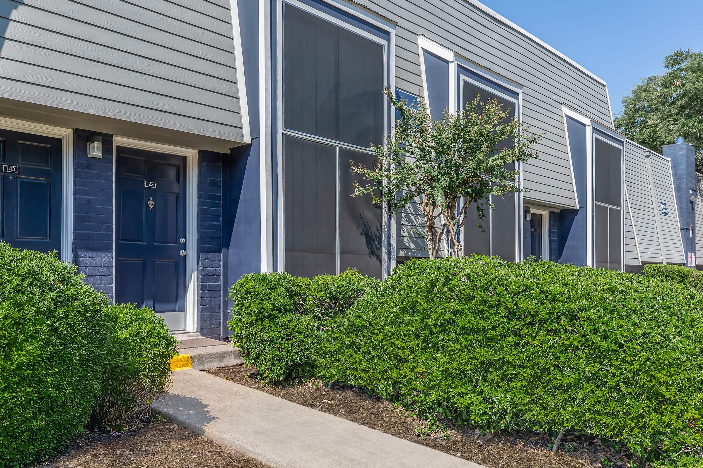 a house with bushes in front of a building