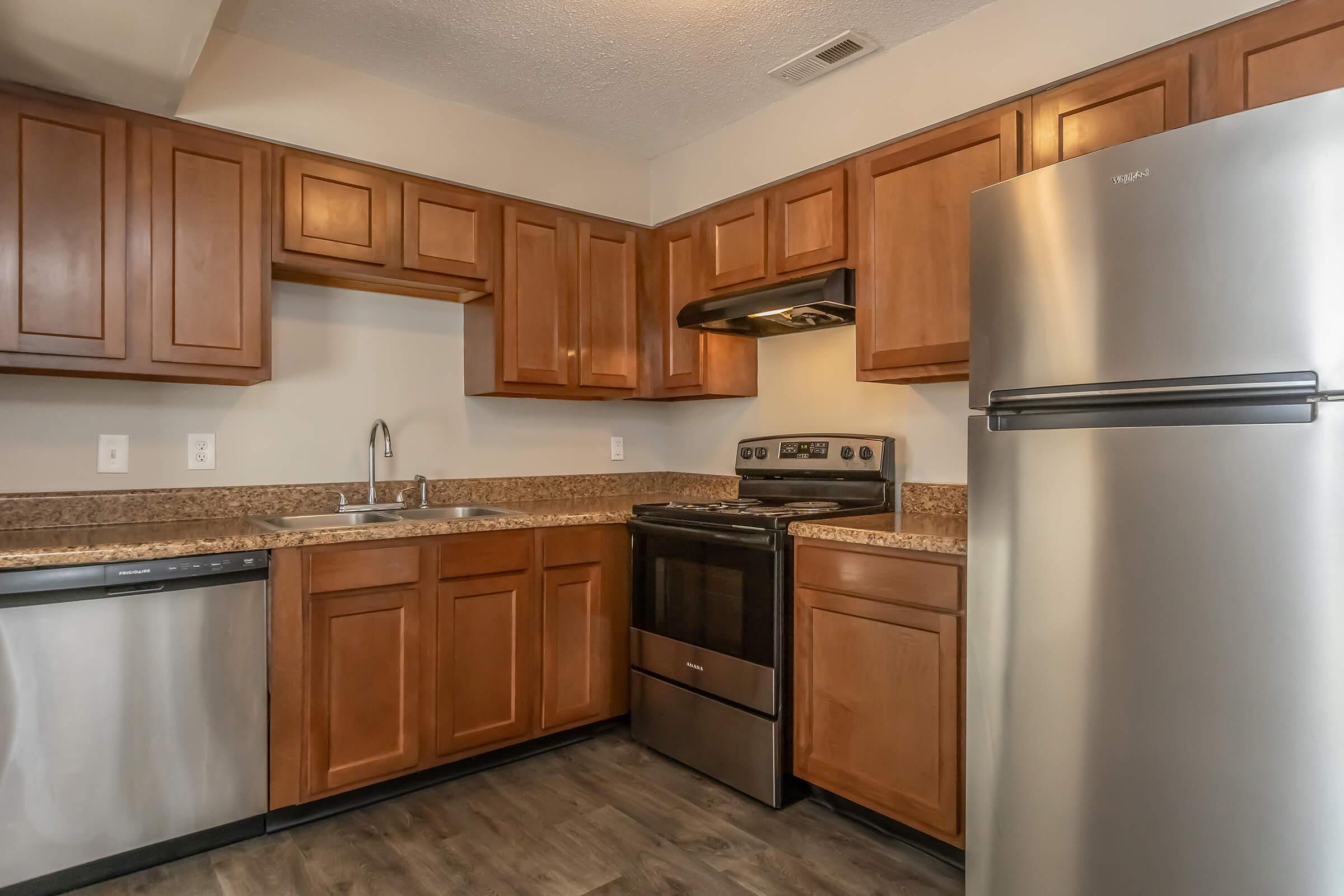 a kitchen with stainless steel appliances and wooden cabinets