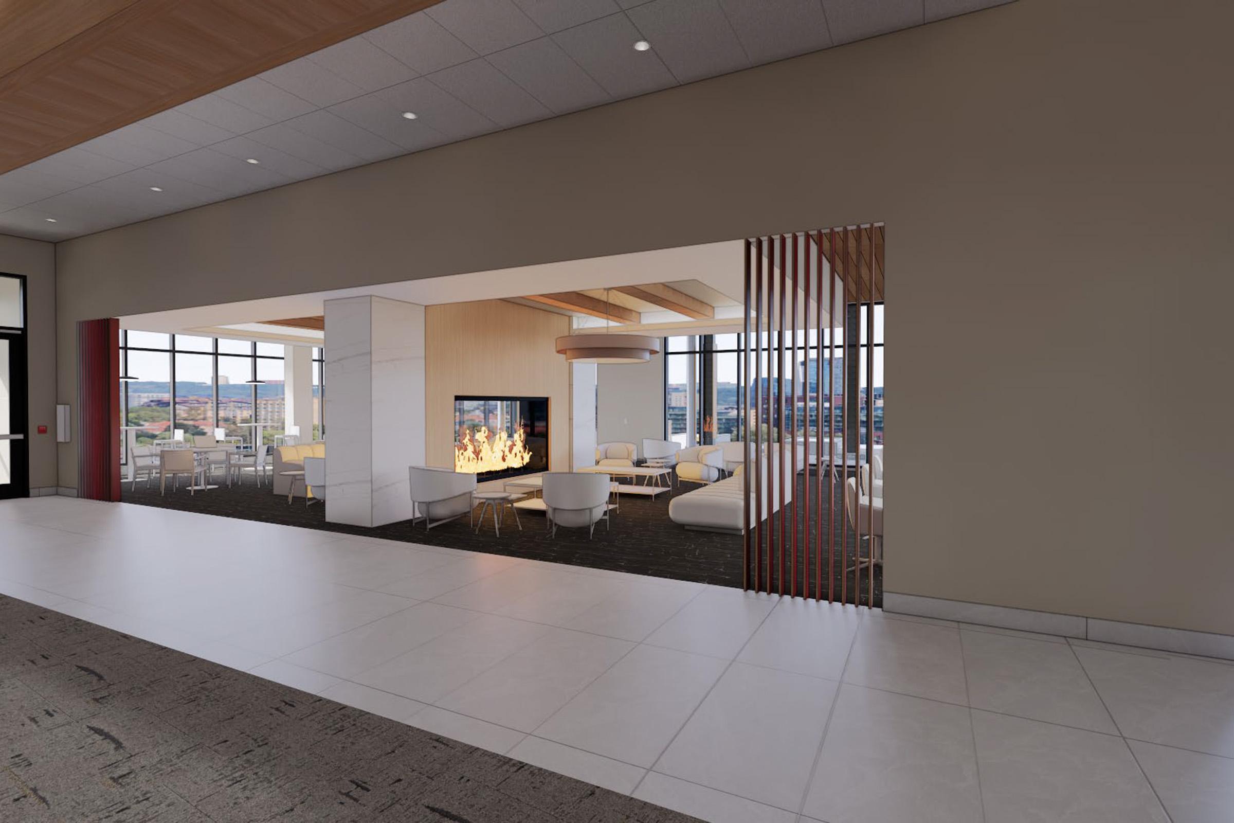 A modern lounge area featuring a central fireplace, with minimalist white furniture and large windows providing a view of the outside. The space is designed with a contemporary aesthetic, incorporating warm wood accents and neutral tones, creating an inviting atmosphere for relaxation or social gatherings.