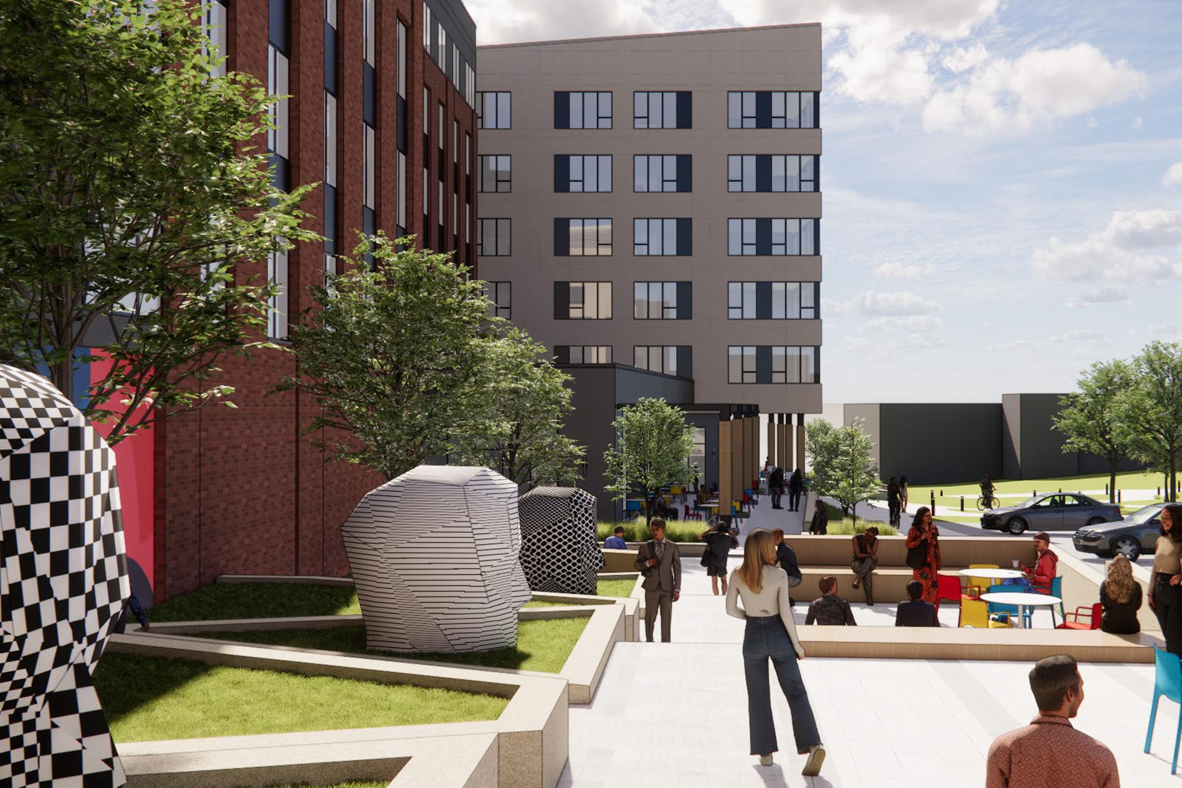 A modern outdoor space featuring a multi-story building with a mix of brick and gray facade. People are enjoying the area, walking along paths surrounded by greenery and artistic sculptures. Colorful seating options are visible, creating a lively atmosphere.