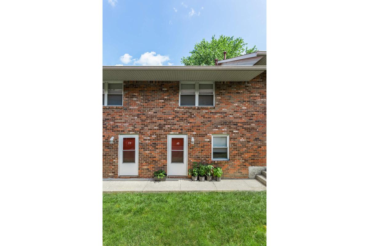 a large brick building with grass in front of a house