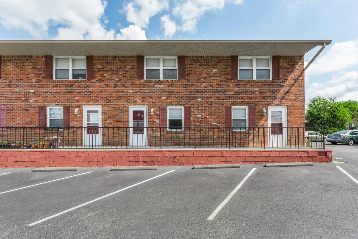 an empty parking lot in front of a brick building