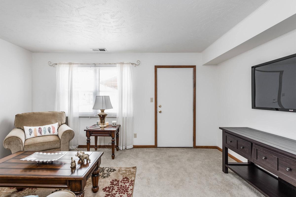 a living room filled with furniture and a flat screen tv