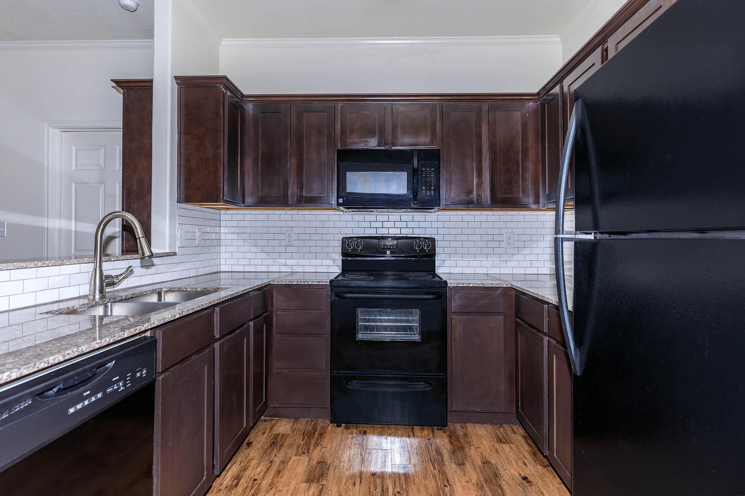 a large kitchen with stainless steel appliances and wooden cabinets