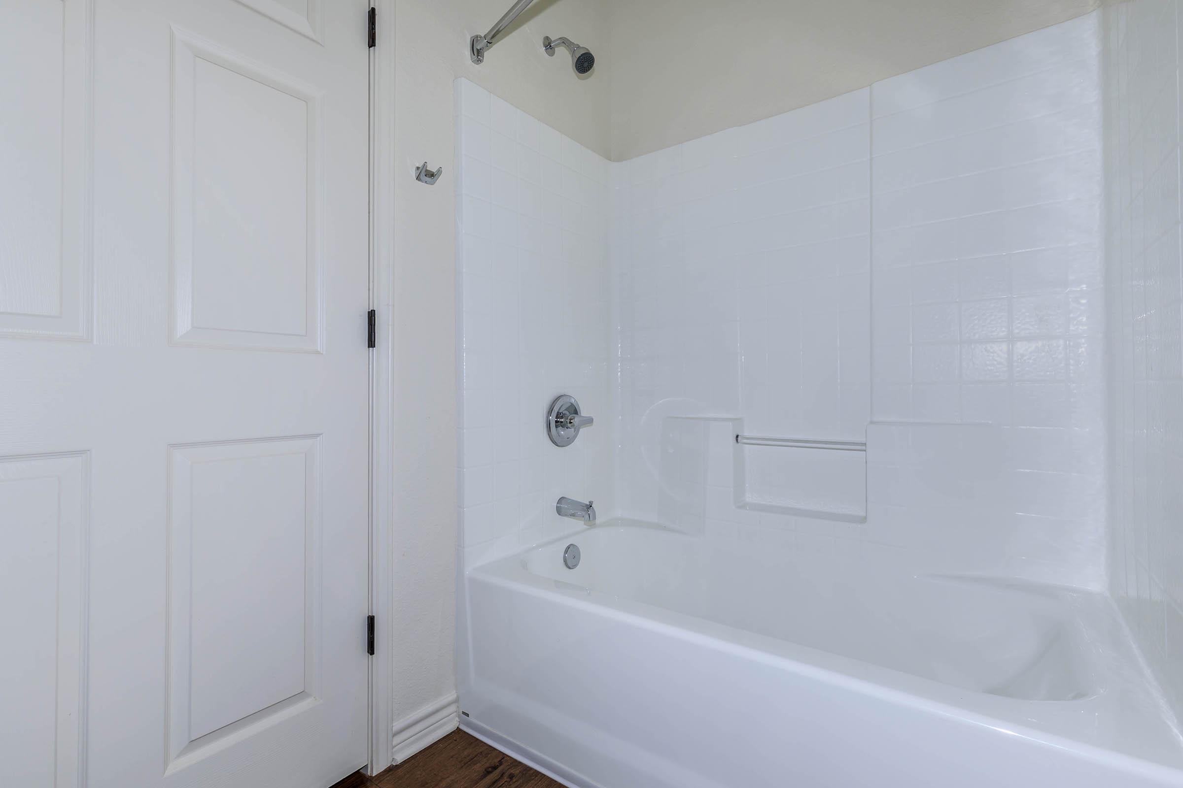 a white tub sitting next to a shower