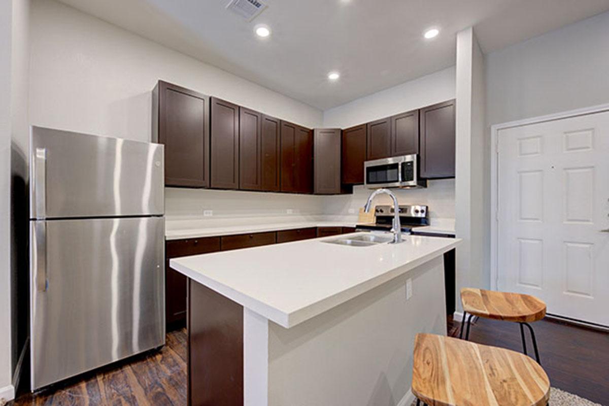 a modern kitchen with stainless steel appliances and wooden cabinets