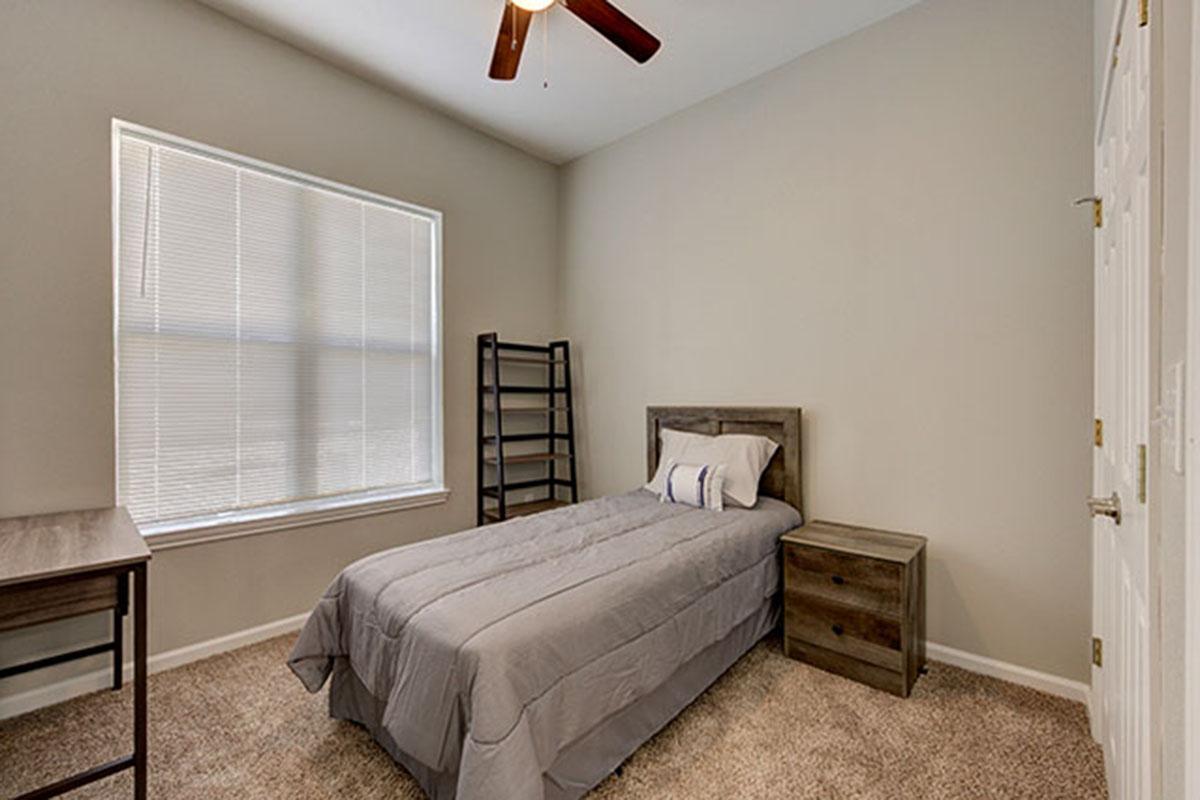 a bedroom with a bed and desk in a room