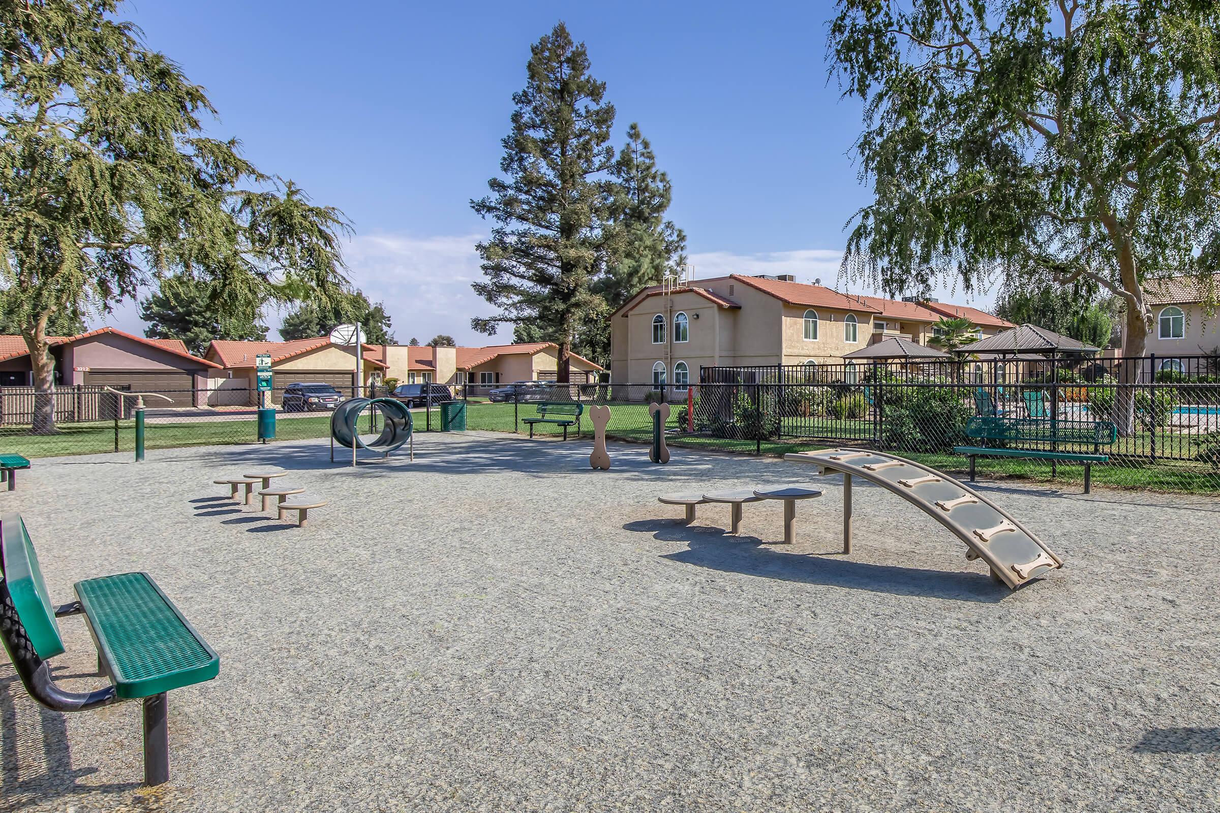 2-Bedroom Apartments in Visalia, CA - Oak View - Pet Park with Wood Chips, Agility Equipment, and Bench Seating