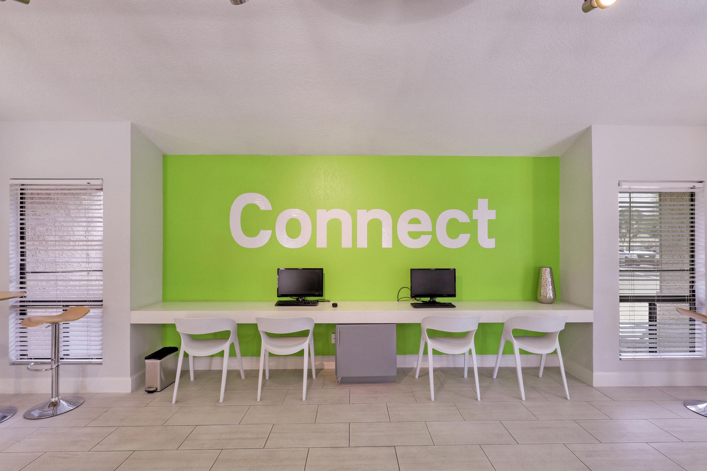 A modern workspace featuring a bright green wall with the word "Connect" in large white letters.