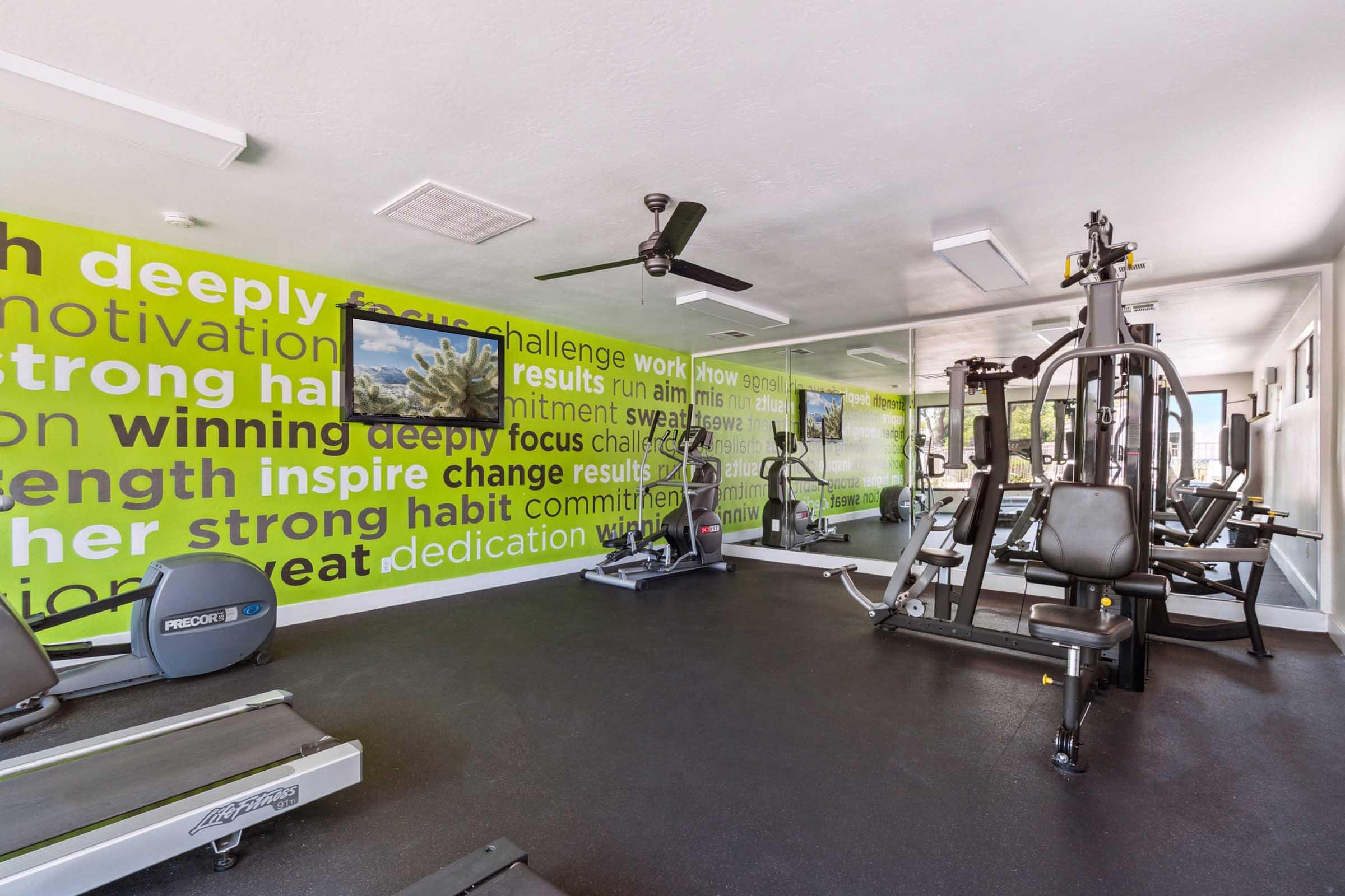 A brightly colored gym with motivational phrases on the walls.