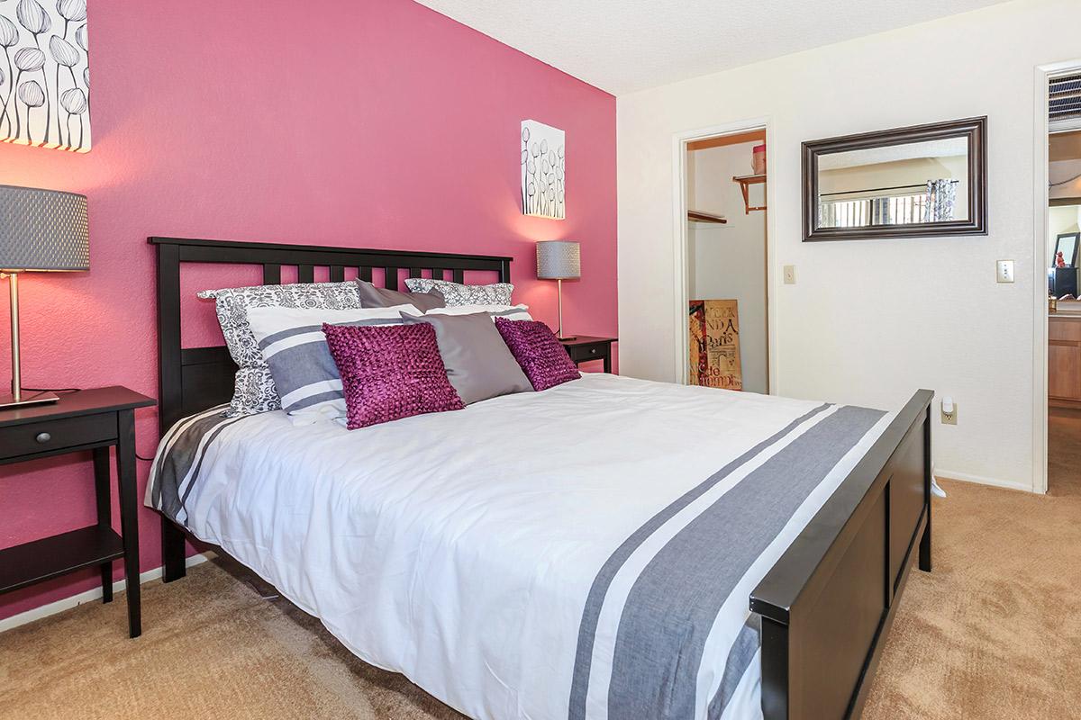 a bedroom with a bed and desk in a hotel room