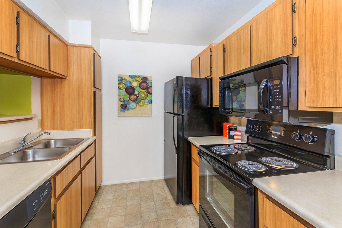 a modern kitchen with stainless steel appliances and wooden cabinets