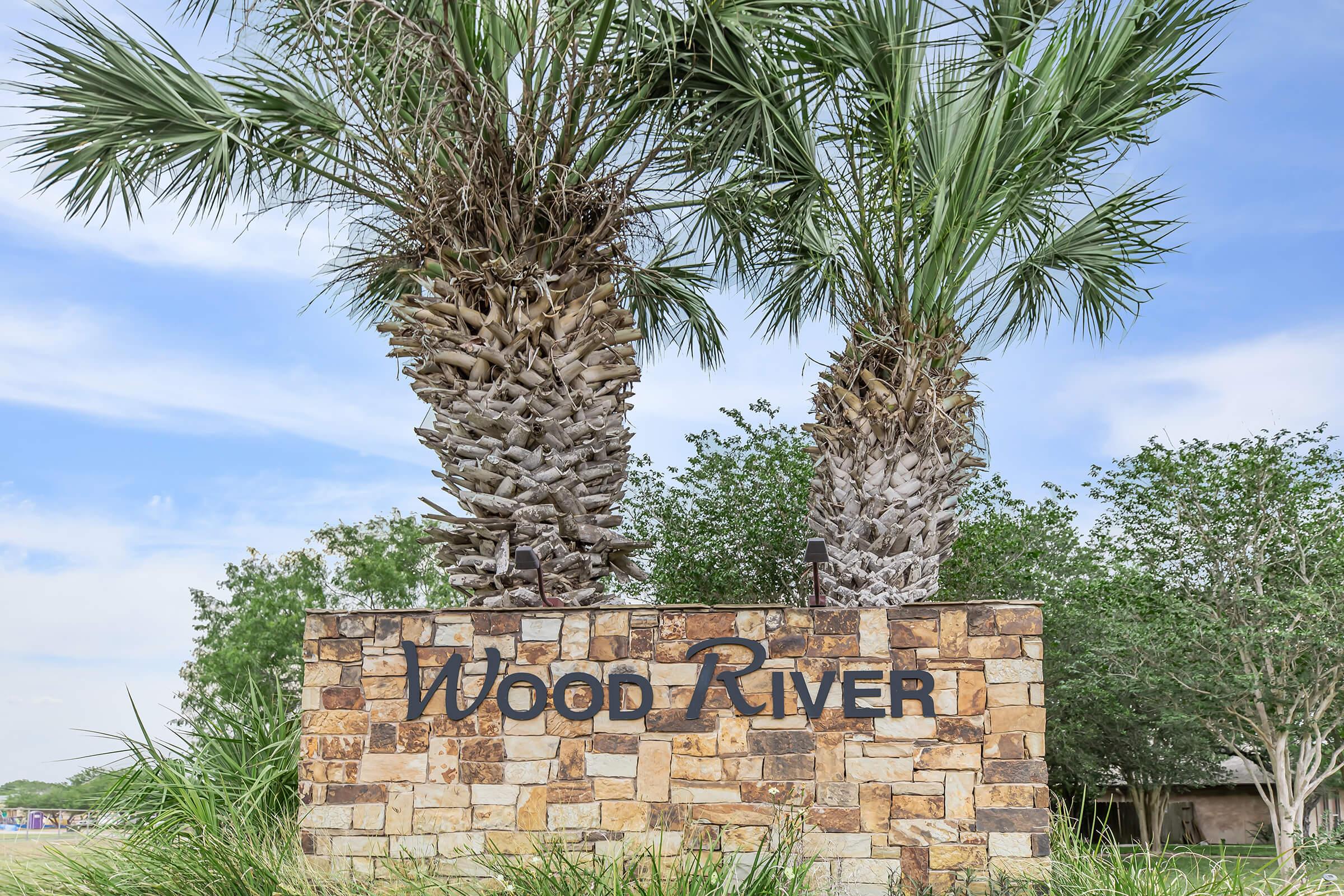 a sign in front of a palm tree