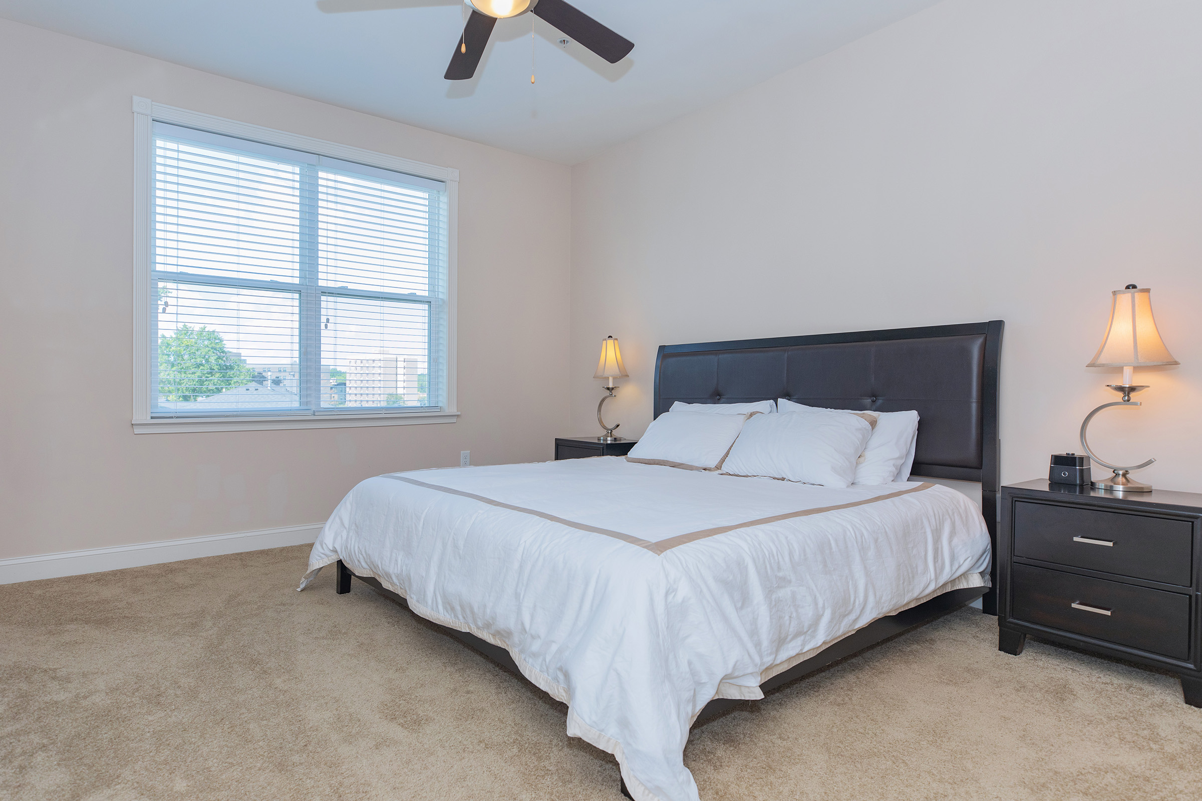 a bedroom with a bed and desk in a room