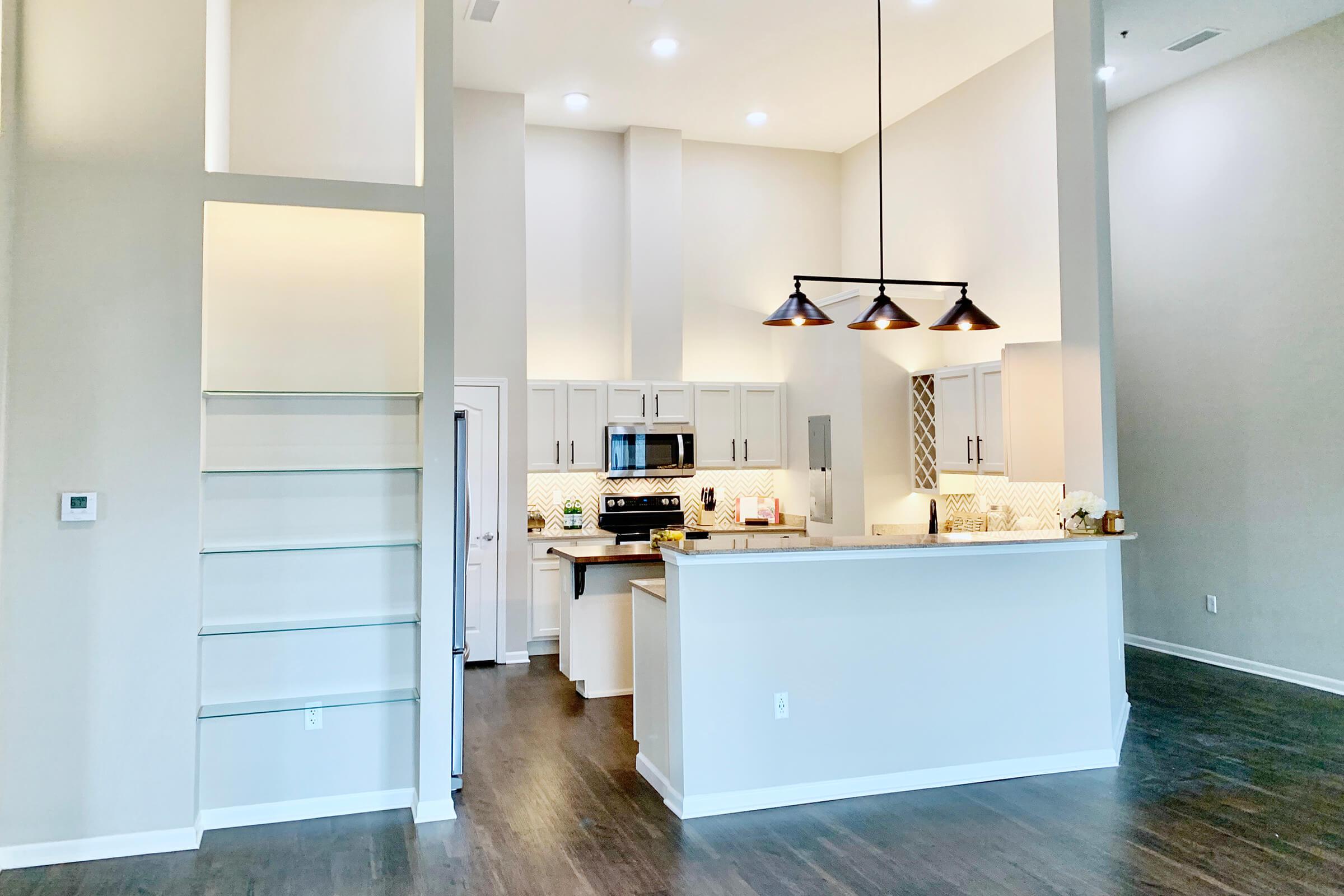 a kitchen with a sink and a mirror in a room