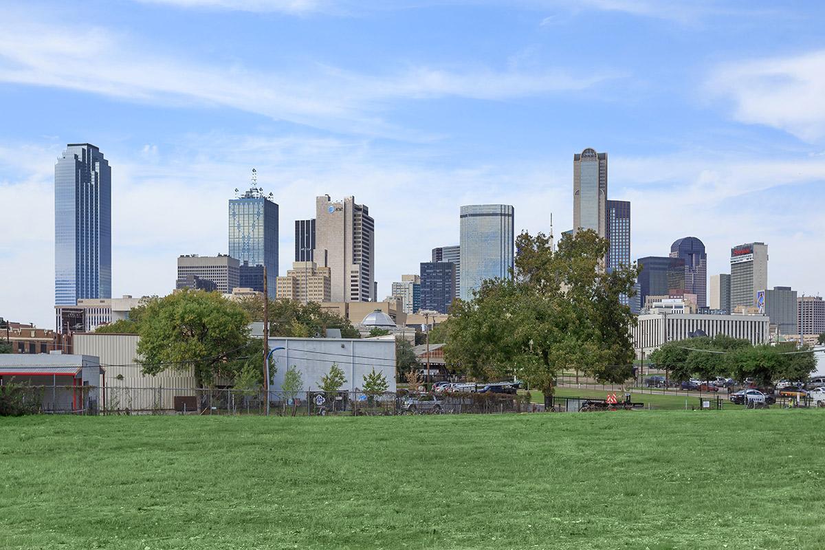 a large green field with a city in the background