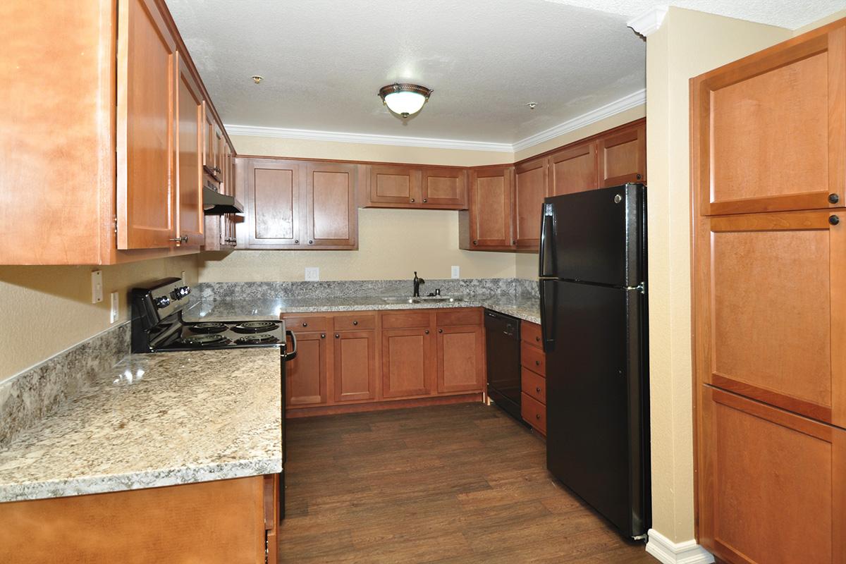 a large kitchen with stainless steel appliances and wooden cabinets