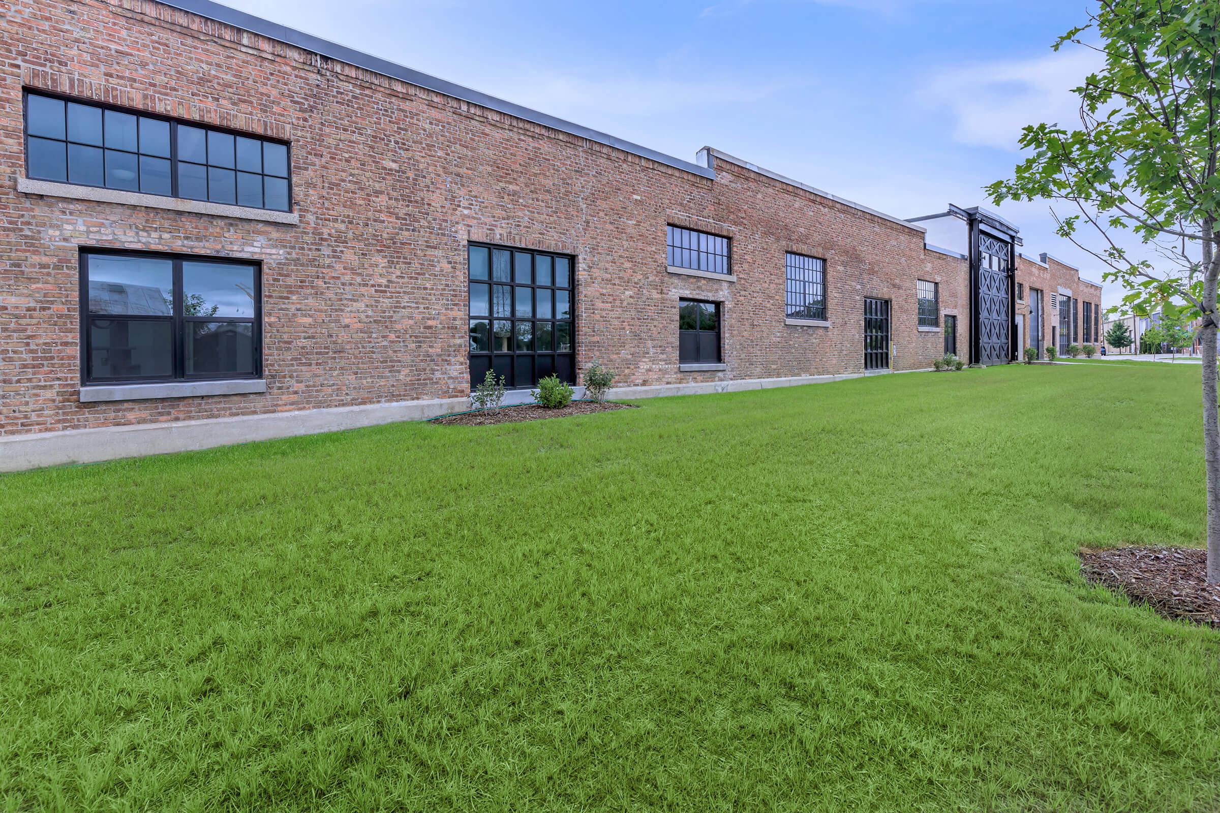a large lawn in front of a brick building