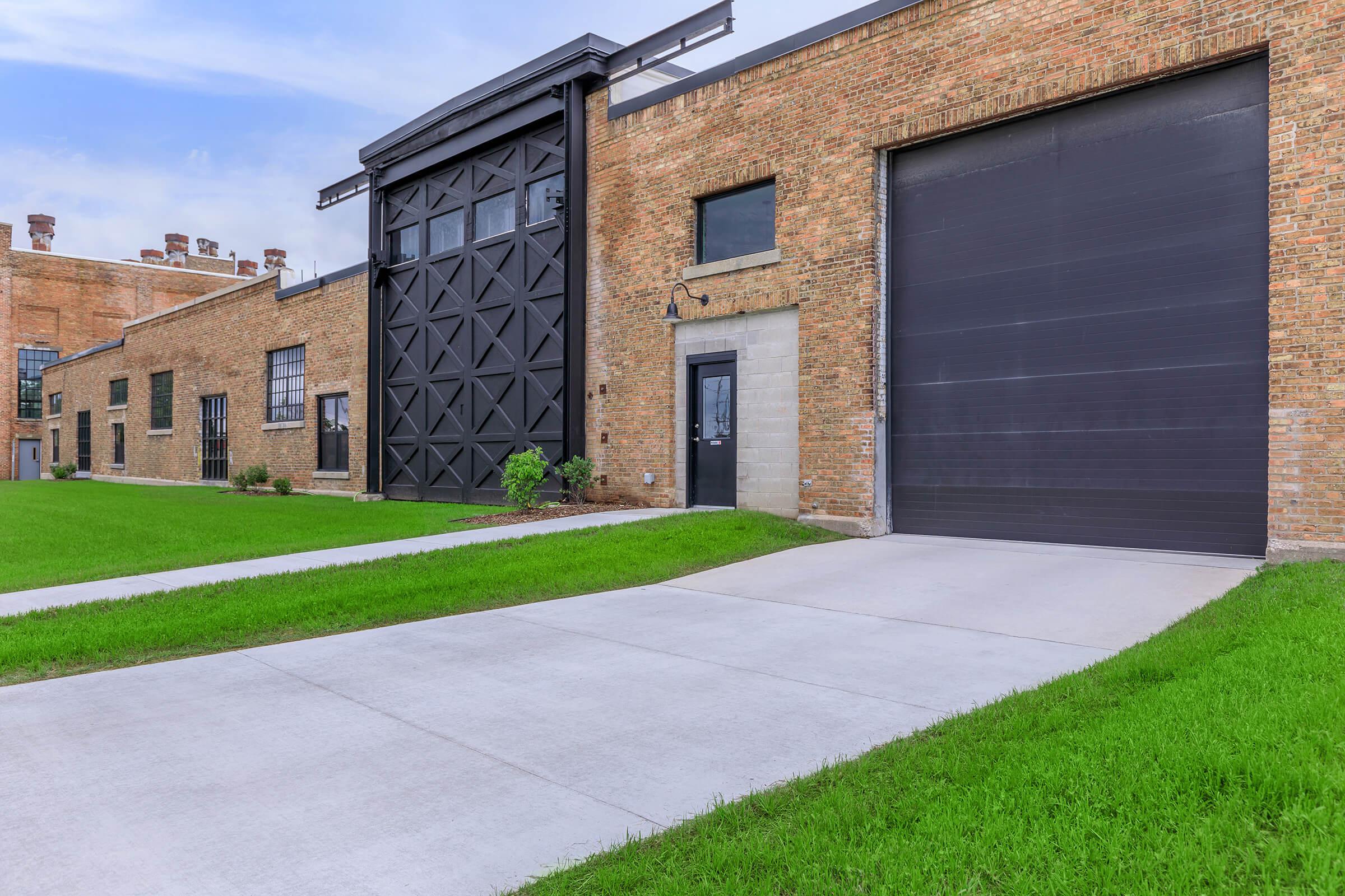 a large brick building with green grass