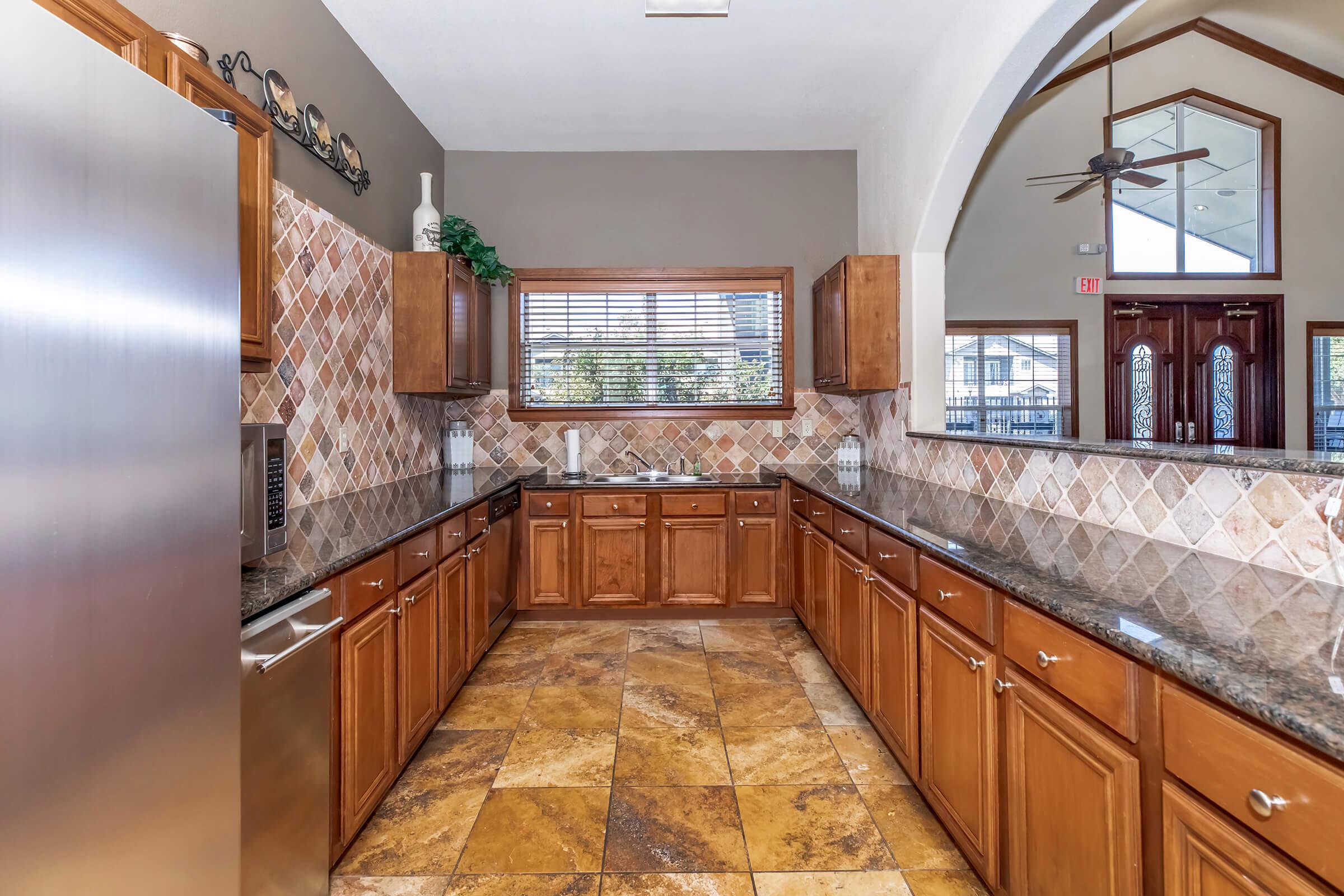 a large kitchen with stainless steel appliances and wooden cabinets