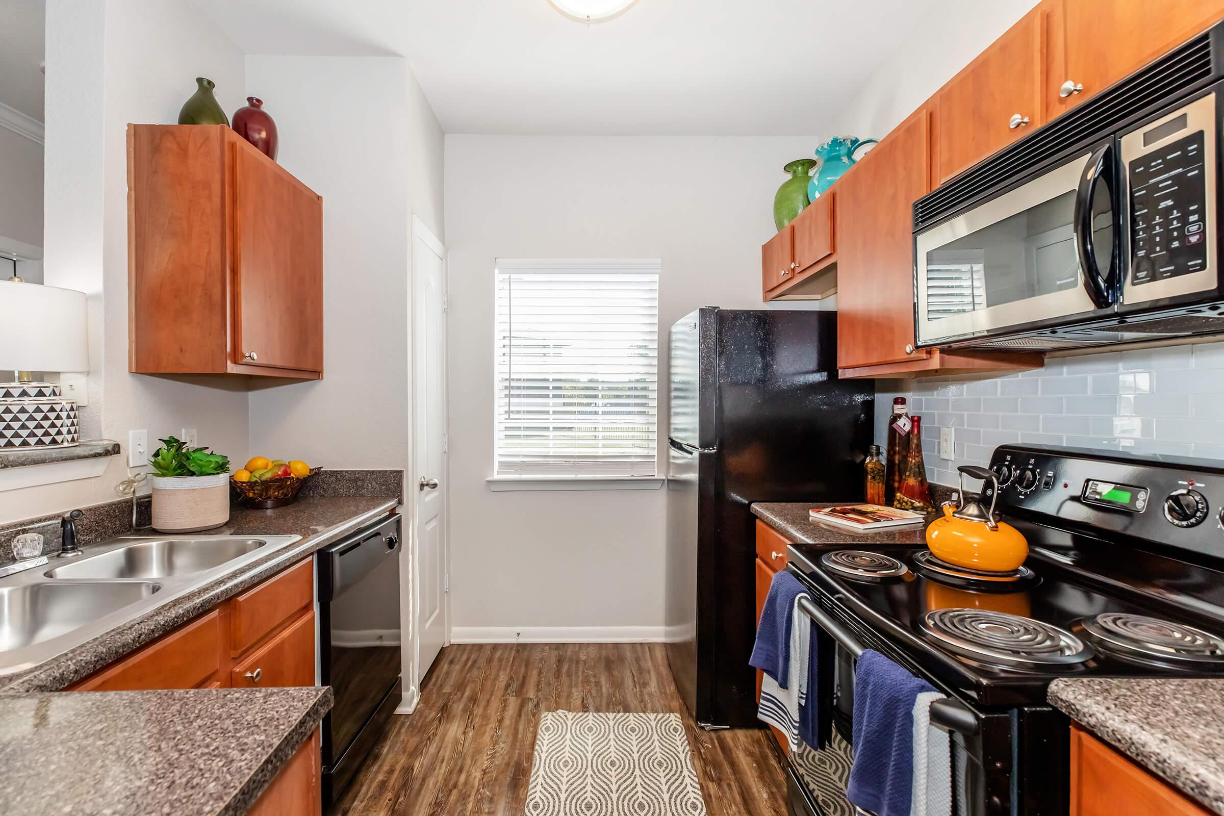 a modern kitchen with stainless steel appliances and wooden cabinets