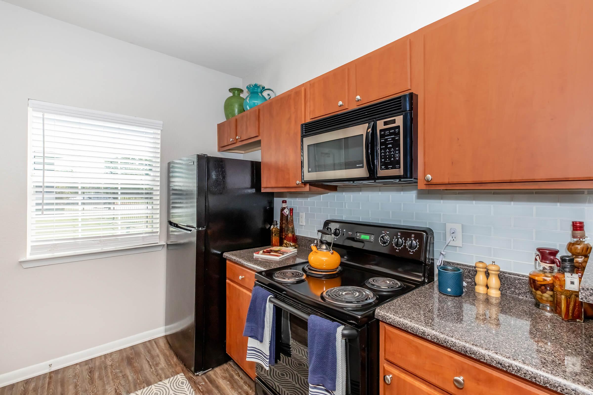 a modern kitchen with stainless steel appliances and wooden cabinets