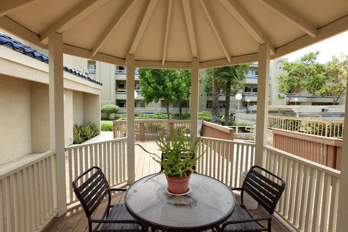 A table and chairs under community gazebo