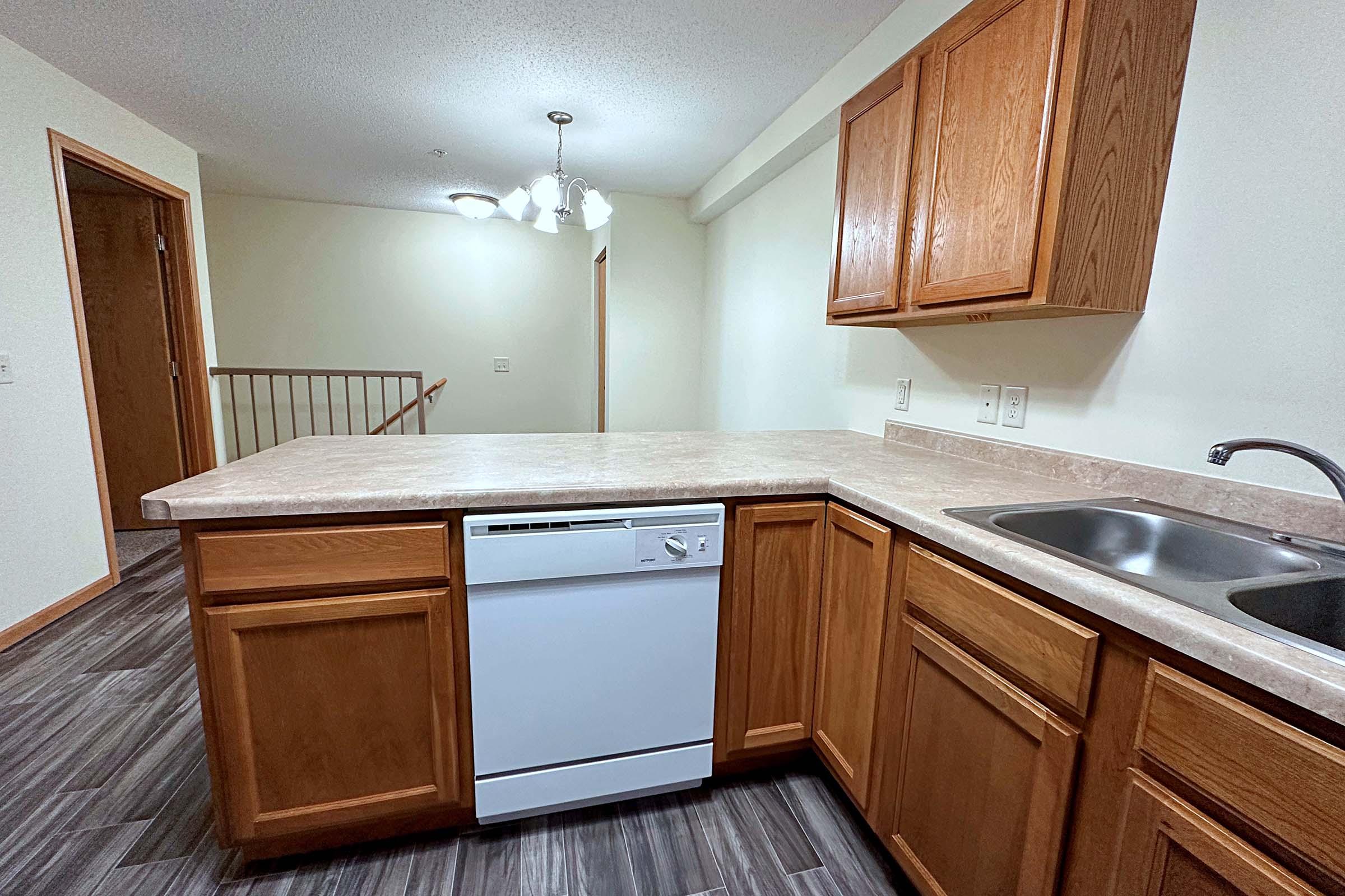 a kitchen with wooden cabinets and a bed