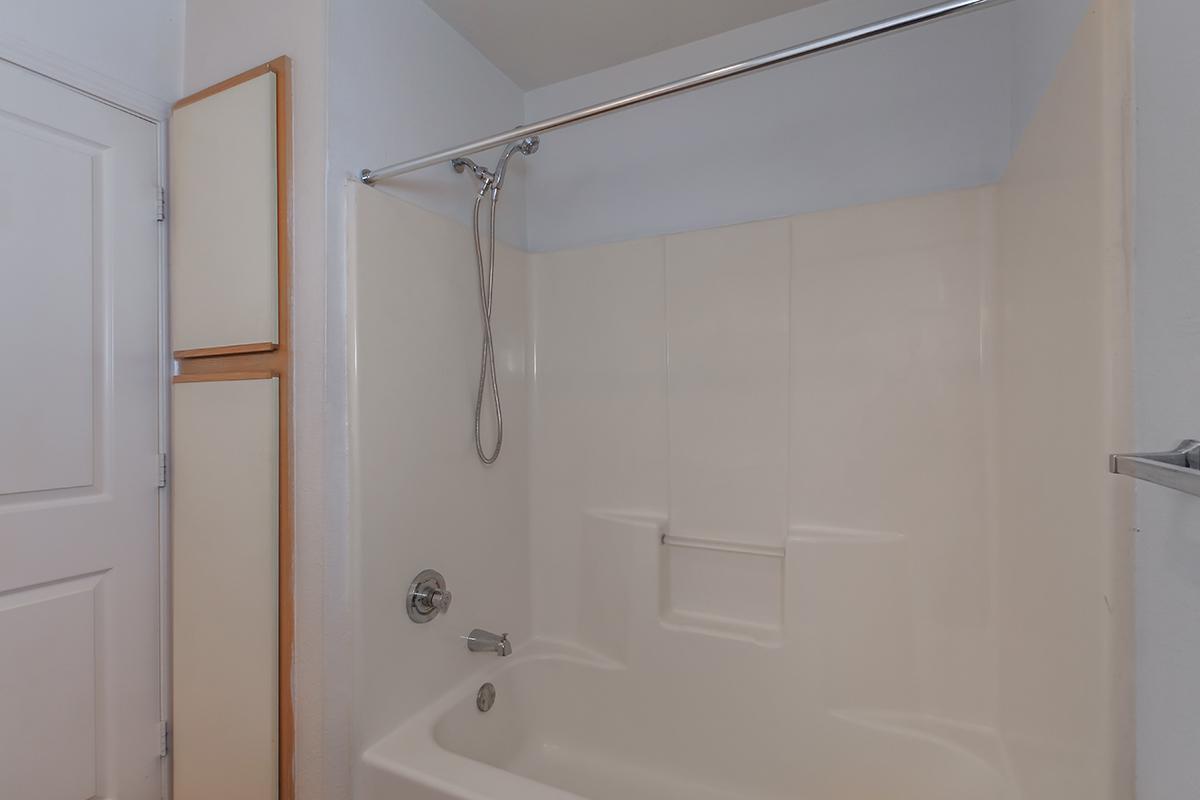 a white tub sitting next to a shower