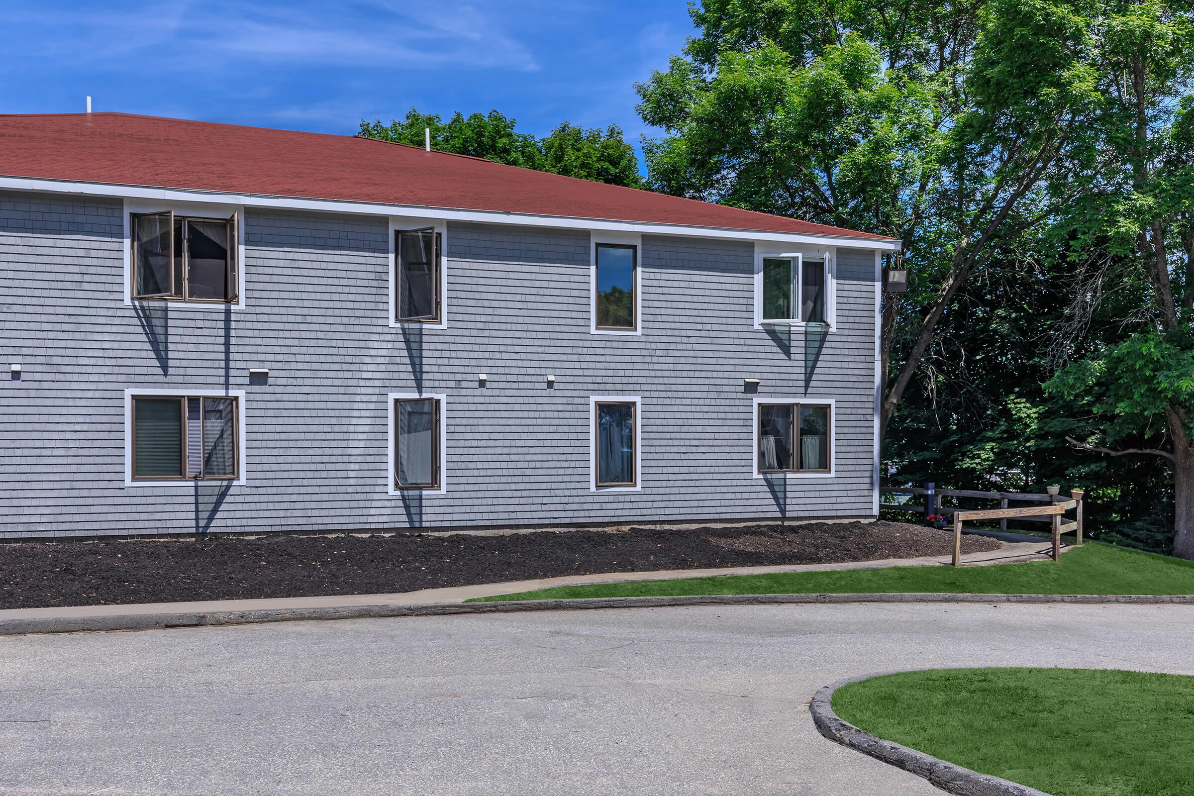 a large brick building with grass in front of a house