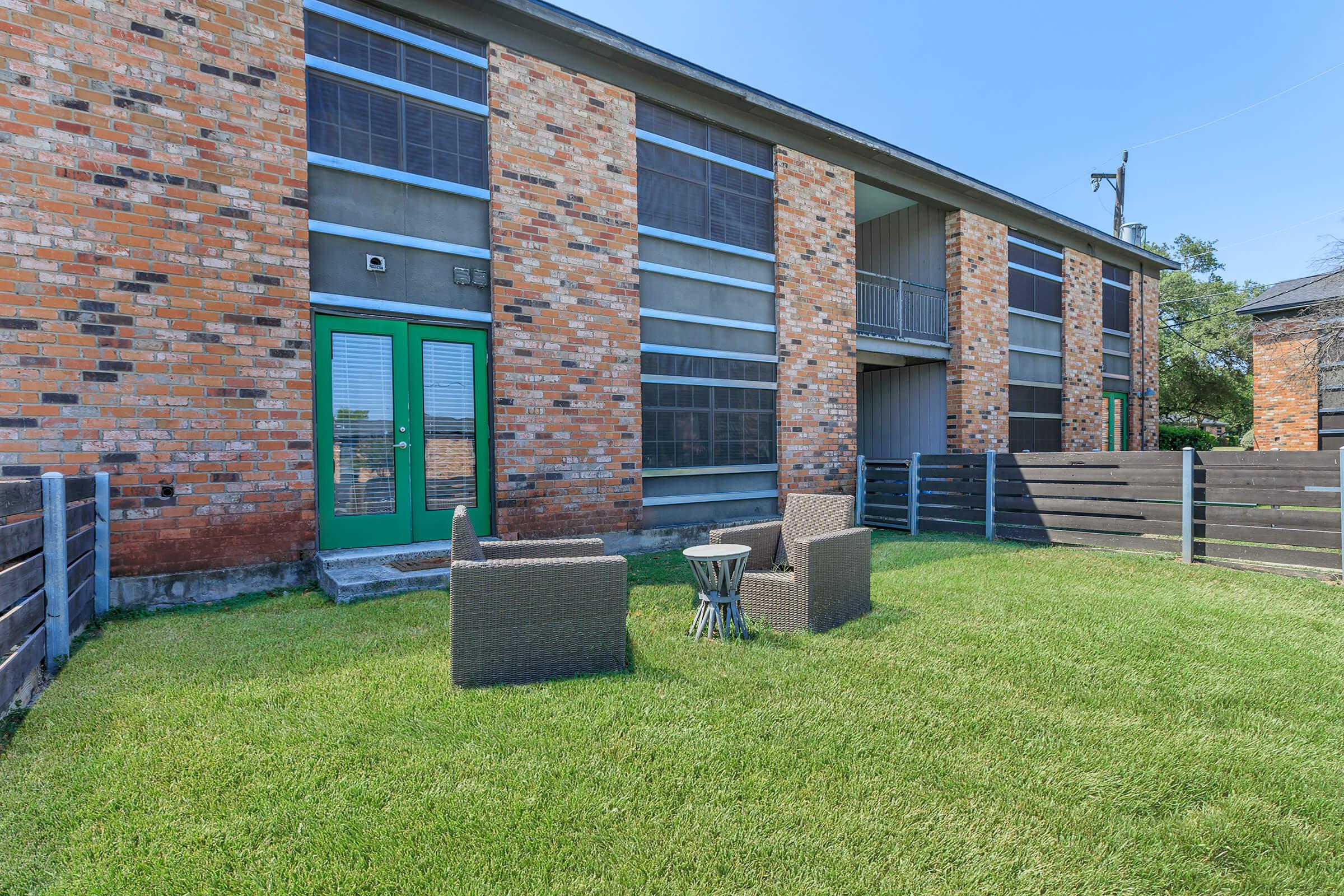 a large lawn in front of a brick building