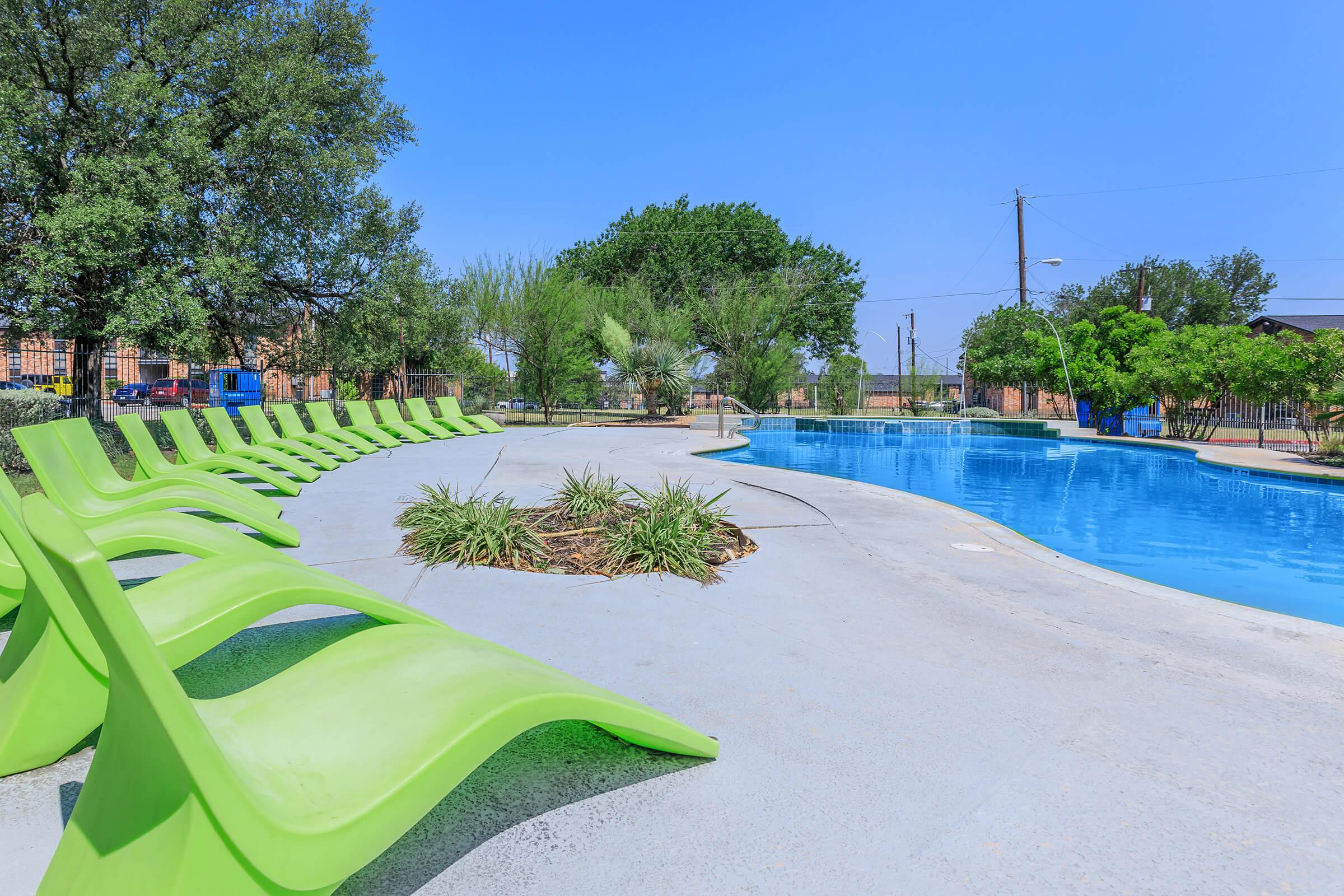 a green chair next to a pool of water