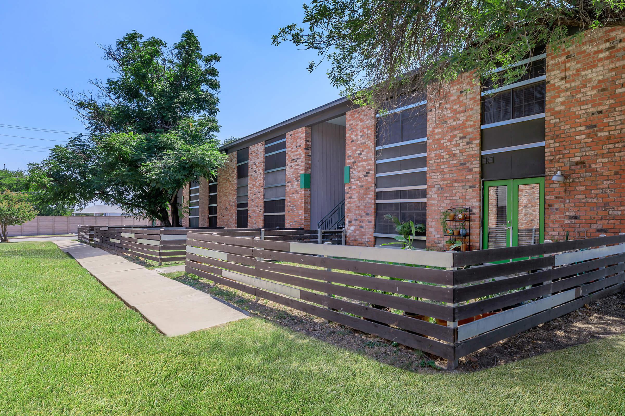 a large lawn in front of a brick building